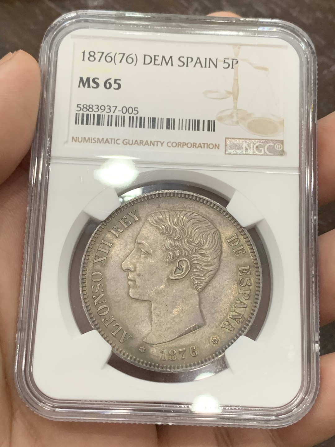 《竞宝斋》第95场-本周日，周一，周四，3场连拍（全场不限金额包邮） 冠军分！NGC MS65 1876西班牙阿方索十二世5比赛塔银币 三版头像中最少见的一版，只发行了两年，且背面纹章也是独一无二的存在，缺少了阿拉贡王国和纳瓦拉王国的纹章，取而代之的是城堡与狮子 同样头像的一枚NGC MS64+在HA拍出了5500美金的价格。