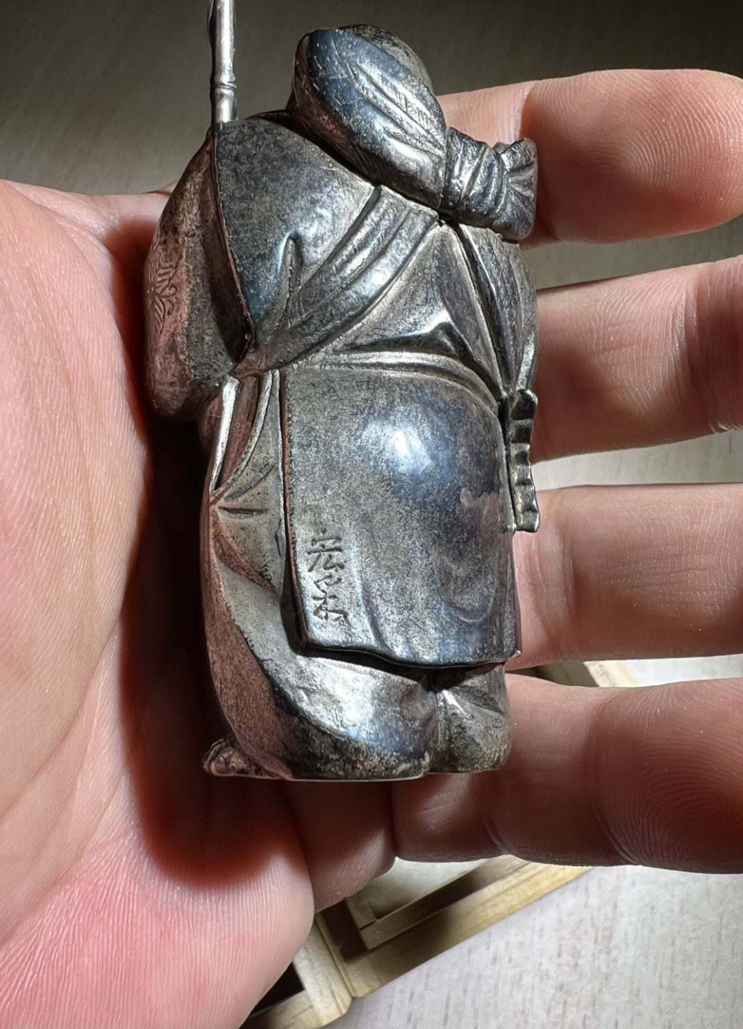 大猫徽章拍卖第205期 纯银财神惠比须摆件，附原木盒，证书 惠比须（亦称惠比寿、夷，日语：えびす）是日本神话中的海神，属于七福神之一，也是七福神中唯一一个日本固有神明。常见的形象是头戴乌帽子、身穿狩衣、右手持钓竿、左手抱鲷鱼的姿态。惠比须是原先是日本渔民信仰的海上守护神，后来由于海运的兴起而成了商业神、财神，到14、15世纪演变为了全日本民众信仰的财神、商业神。日本著名金工，佐野宏行，号宏采，制作。