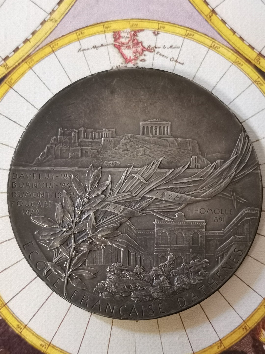 橡树集藏-006场 海纳百川 法国铜镀银章 雅典法国学校 1898年巴黎铸币厂 罗蒂roty作品 60mm 100.32g 丰饶角 考古形象玛丽安娜坐在倒下的柱子上 手持小雕像 周围有其他被挖掘的文物 背景是雅典废墟和山城景观 背面希腊雅典卫城景观 下方是缠绕着月桂枝和棕榈叶以及学校的立体建筑空间 浅银灰色表面 迷人的哑光表面 优雅的新艺术风格设计 设计绝美 雍容华贵 百年名章大名誉品 比法百少多了 sbp同款铜章960刀 