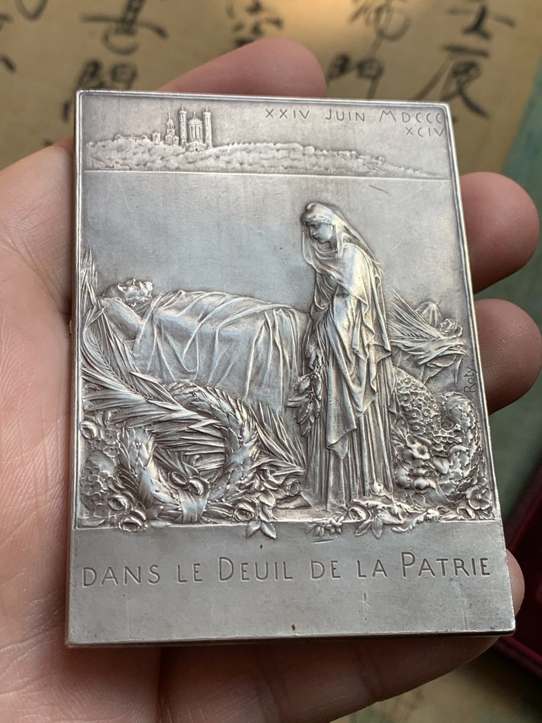 《竞宝斋》第108场-周日，周一 ，周四3场连拍（全场包邮） 法国 1894年卡诺总统葬礼纪念镀银大铜章，带原盒。雕刻大师罗蒂（O Roty）名作，直径80mm*57mm。正面图案为玛丽安娜女神站立于花环簇拥的总统遗体旁，背面一群身穿长袍黑纱的人将棺椁抬向先贤祠