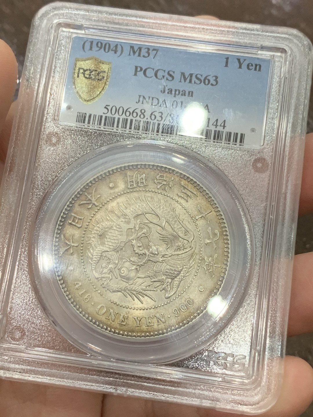 《竞宝斋》第108场-周日，周一 ，周四3场连拍（全场包邮） PCGS-MS63 日本1904年 明治37年一圆 银币，环彩漂亮包浆 背面盒子有一裂痕不影响币