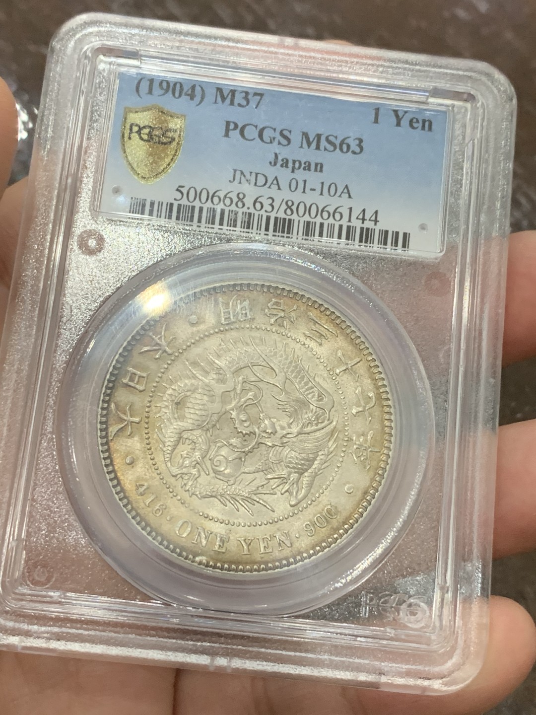 《竞宝斋》第108场-周日，周一 ，周四3场连拍（全场包邮） PCGS-MS63 日本1904年 明治37年一圆 银币，环彩漂亮包浆 背面盒子有一裂痕不影响币
