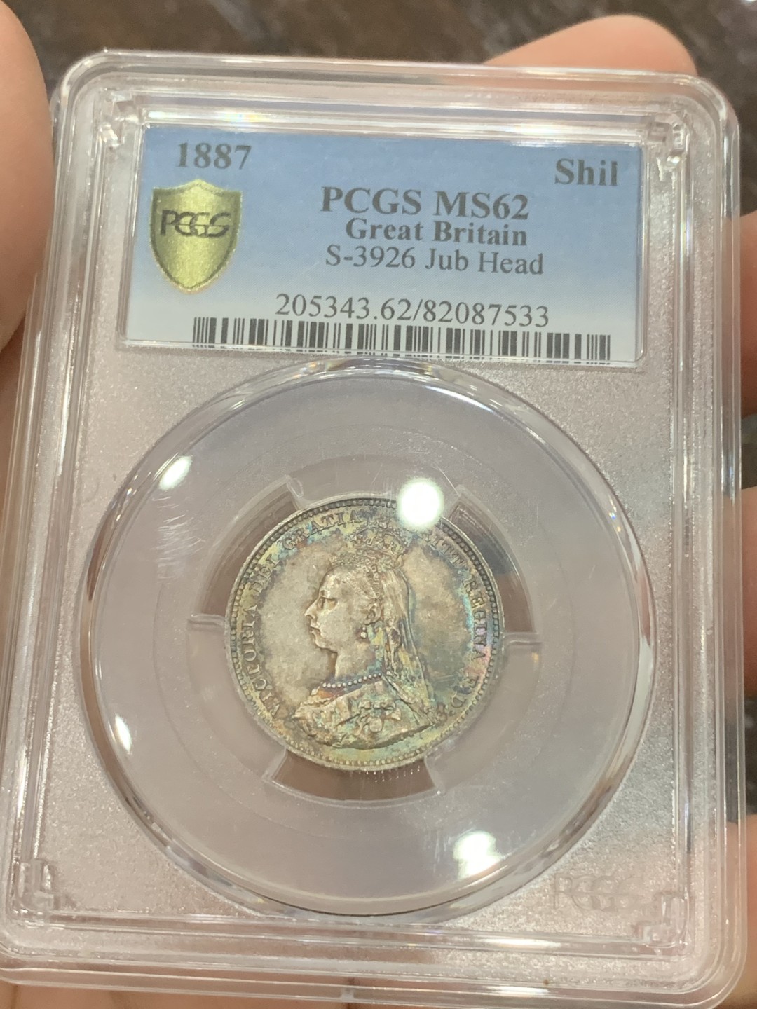 《竞宝斋》第108场-周日，周一 ，周四3场连拍（全场包邮） PCGS-MS62英国1887年维多利亚高冠一先令银币 两面彩虹彩 五彩斑斓美不胜收 细节也到位 不可多得的一颗