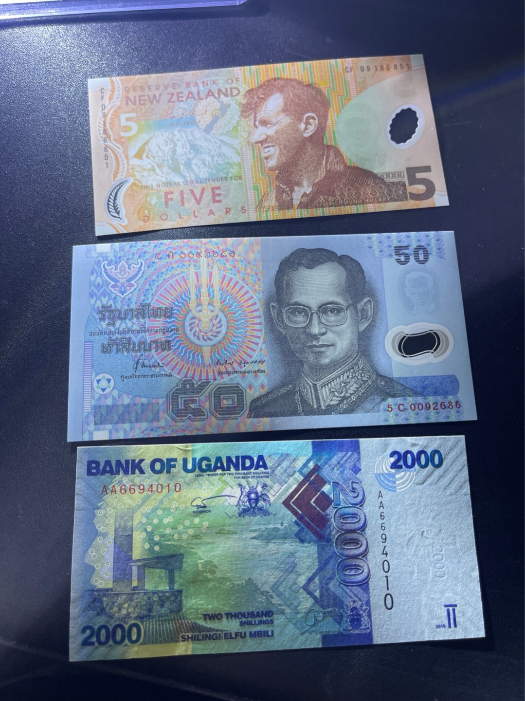 《外钞收藏家》第二百一十二期 乌干达2000 AA冠、新西兰5元、泰铢50三张一起 全新UNC