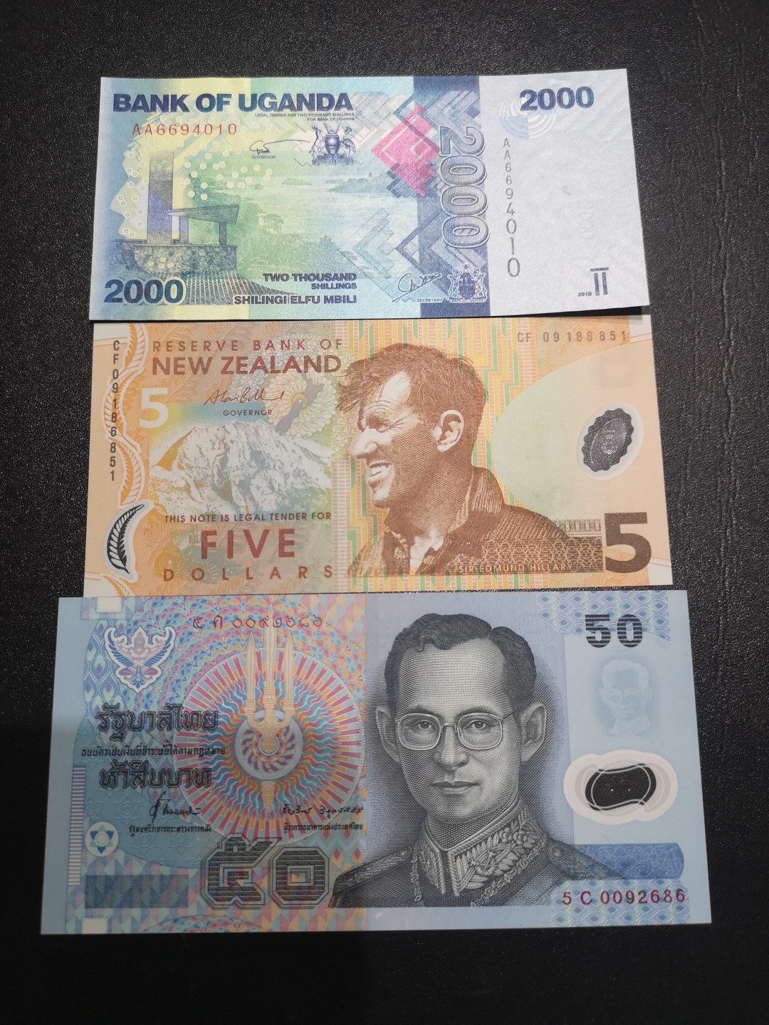 《外钞收藏家》第二百一十二期 乌干达2000 AA冠、新西兰5元、泰铢50三张一起 全新UNC