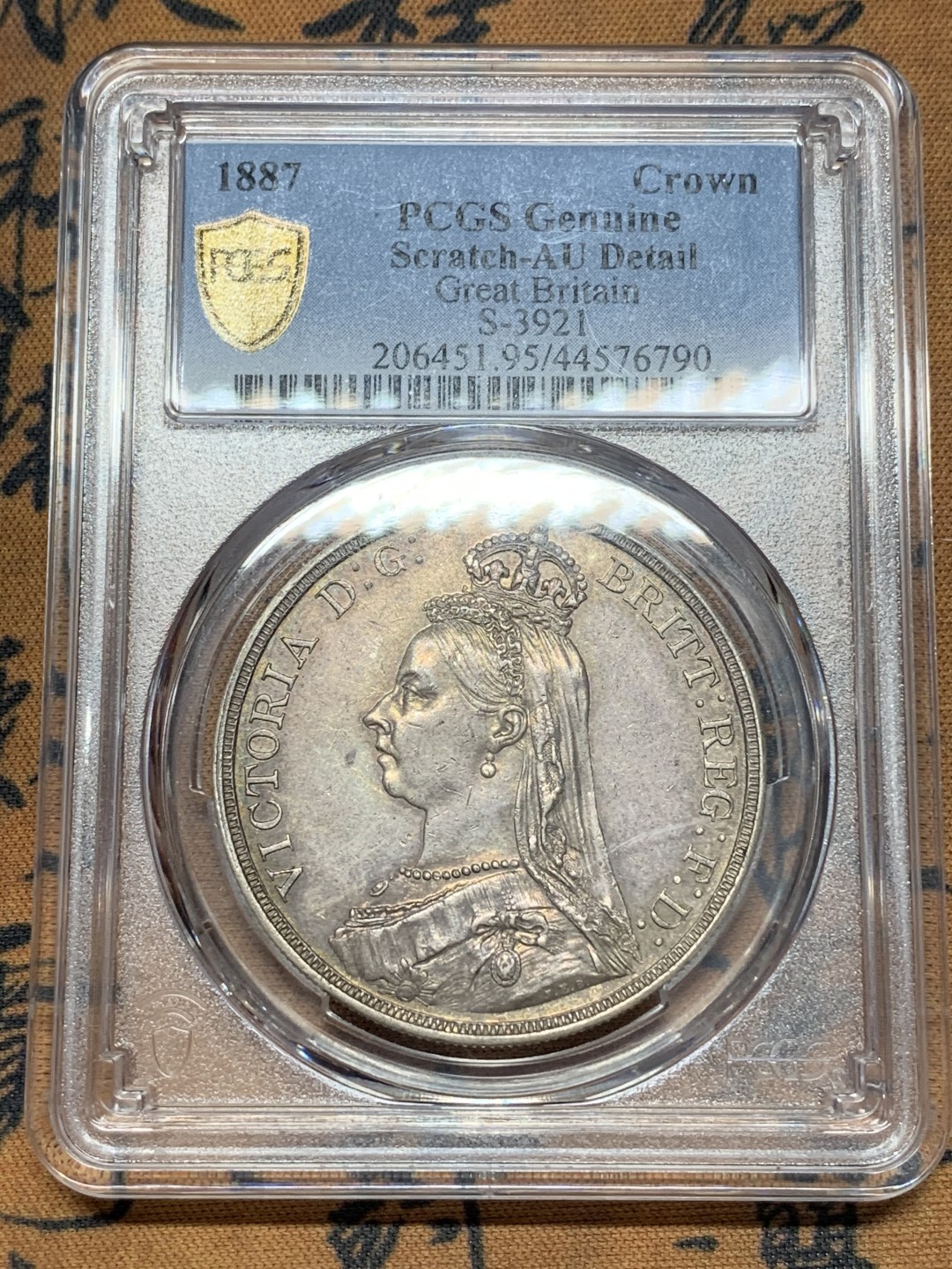 《竞宝斋》第111场-周日，周一 ，2场连拍（全场包邮） PCGS AU好品 英国1887年维多利亚高冠马剑一克朗银币背面非常好正面脸上一个小划痕 适为包浆磨损