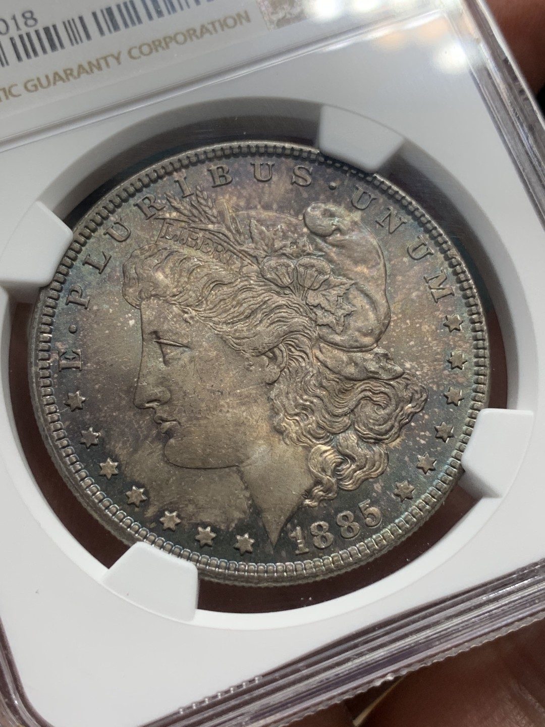 《竞宝斋》第112场-周日，周一 ，2场连拍（全场包邮） NGC-MS64 美国 1885年 摩根银币 女神面满彩 鹰面彩中彩 背斑驳彩 2点-6点方向深蓝月牙