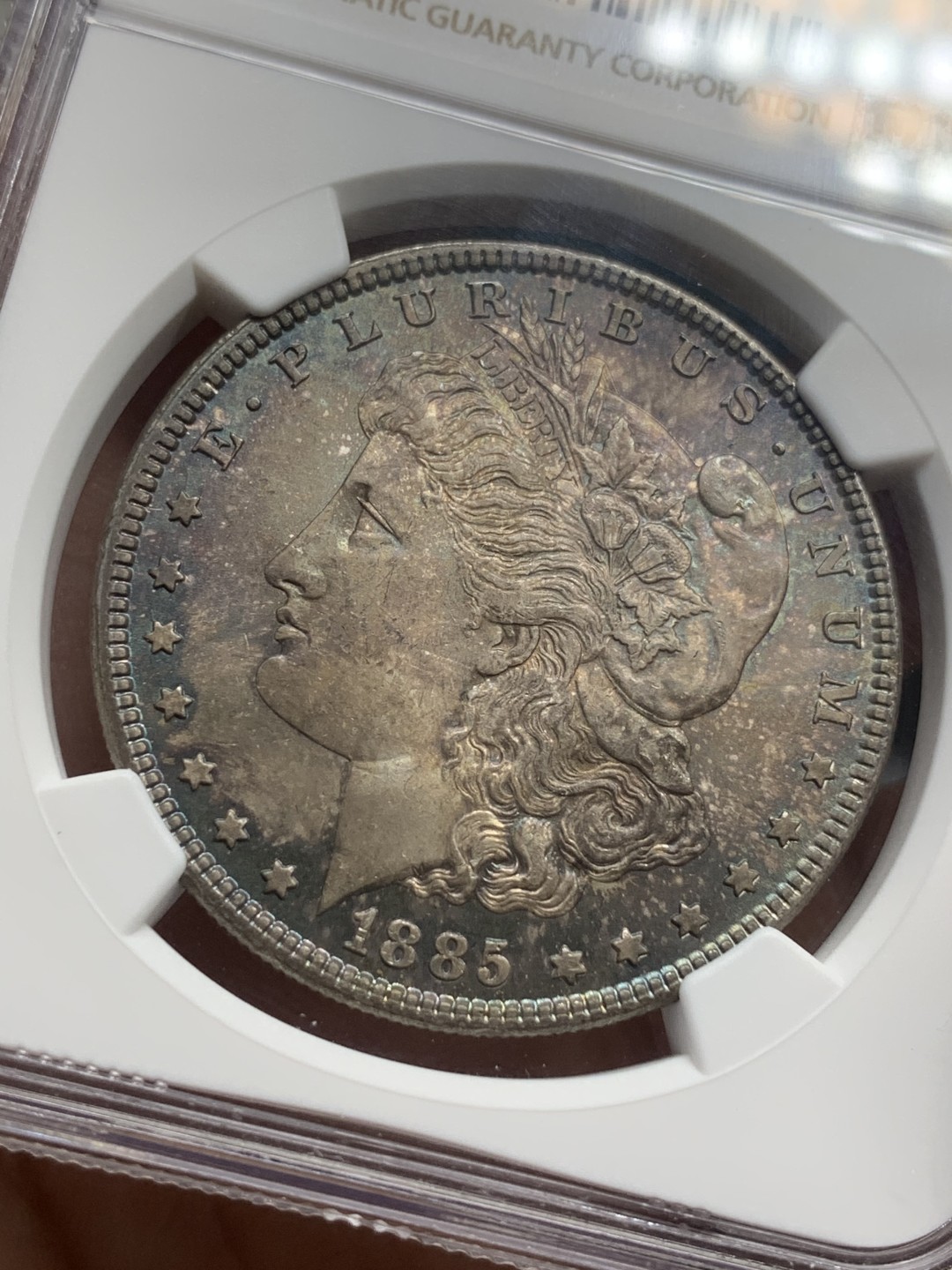 《竞宝斋》第112场-周日，周一 ，2场连拍（全场包邮） NGC-MS64 美国 1885年 摩根银币 女神面满彩 鹰面彩中彩 背斑驳彩 2点-6点方向深蓝月牙