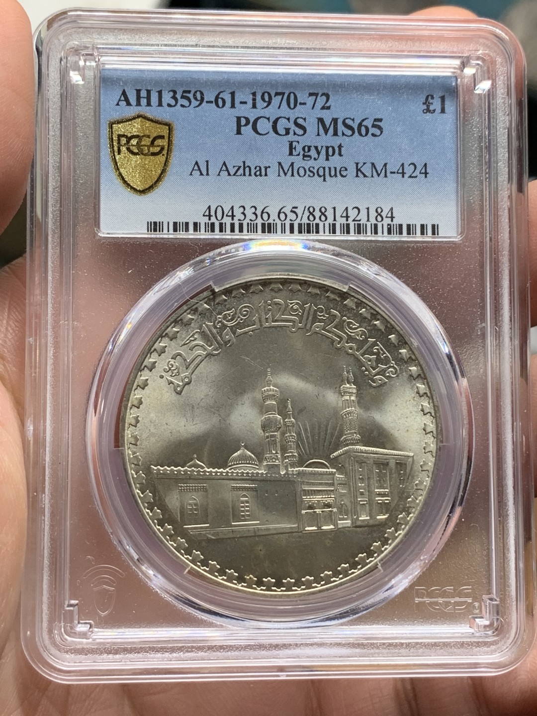 《竞宝斋》第113场-周日，周一 ，2场连拍（全场包邮） PCGS MS65 埃及1970年爱资哈尔清真大寺图案1镑大银币。爱资哈尔清真大寺位于埃及开罗城东南，为法蒂玛王朝大将昭海尔于970年修建开罗城的同时动工兴建