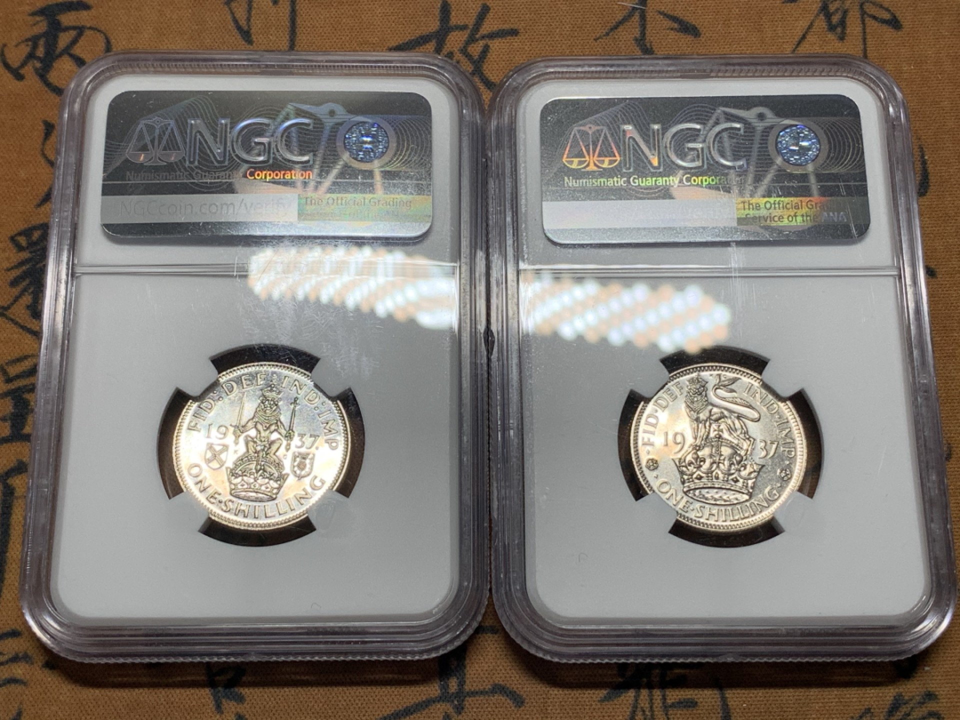 《竞宝斋》第115场-周日，周一 ，2场连拍（全场包邮） NGC-PF64-65 1937年乔治六世加冕首年精制银币，1先令一对（england、scottish），经典狮子币，品相不错 其中一个鼓盒