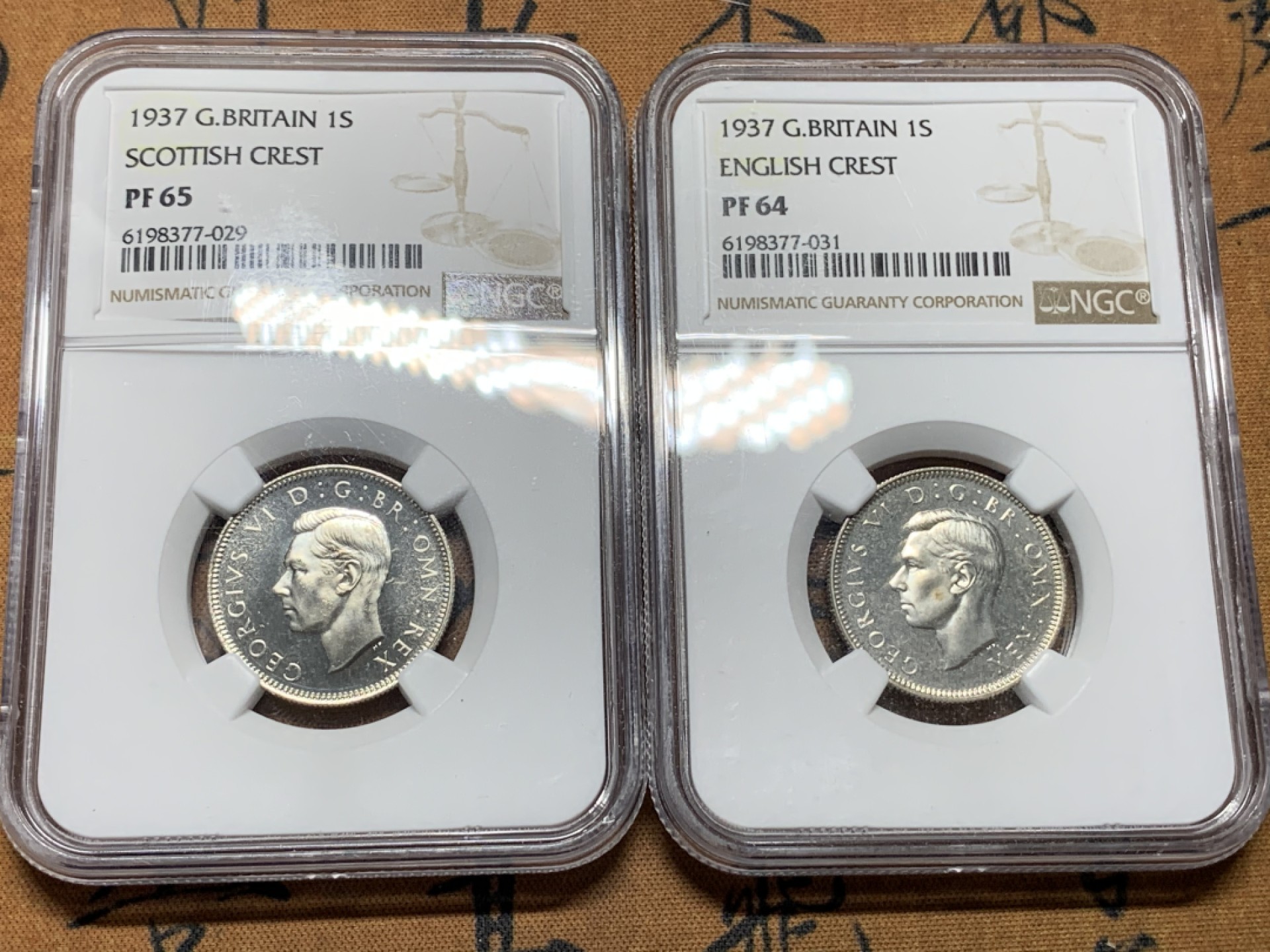 《竞宝斋》第115场-周日，周一 ，2场连拍（全场包邮） NGC-PF64-65 1937年乔治六世加冕首年精制银币，1先令一对（england、scottish），经典狮子币，品相不错 其中一个鼓盒