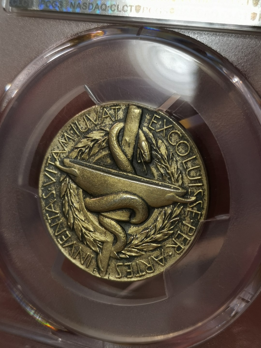 橡树集藏-006场 海纳百川 PCGS-SP64 1985年诺贝尔医学奖镀金银样章，瑞典皇家造币厂铸造，诺贝尔提名委员会颁发，真正的历史荣誉品，错过后悔。独一无二的包浆，实物状态极美。亚军分。正面：諾貝爾半身像朝左；反面：INVENTAS VITAM IUVAT EXCOLUISSE PER ARTES （意：獻給推動人類生活進步的偉大發明家）器皿及埃庫拉皮烏斯的蛇形纏繞權杖；花圈於背。深打，有光帶淺金色調包漿。