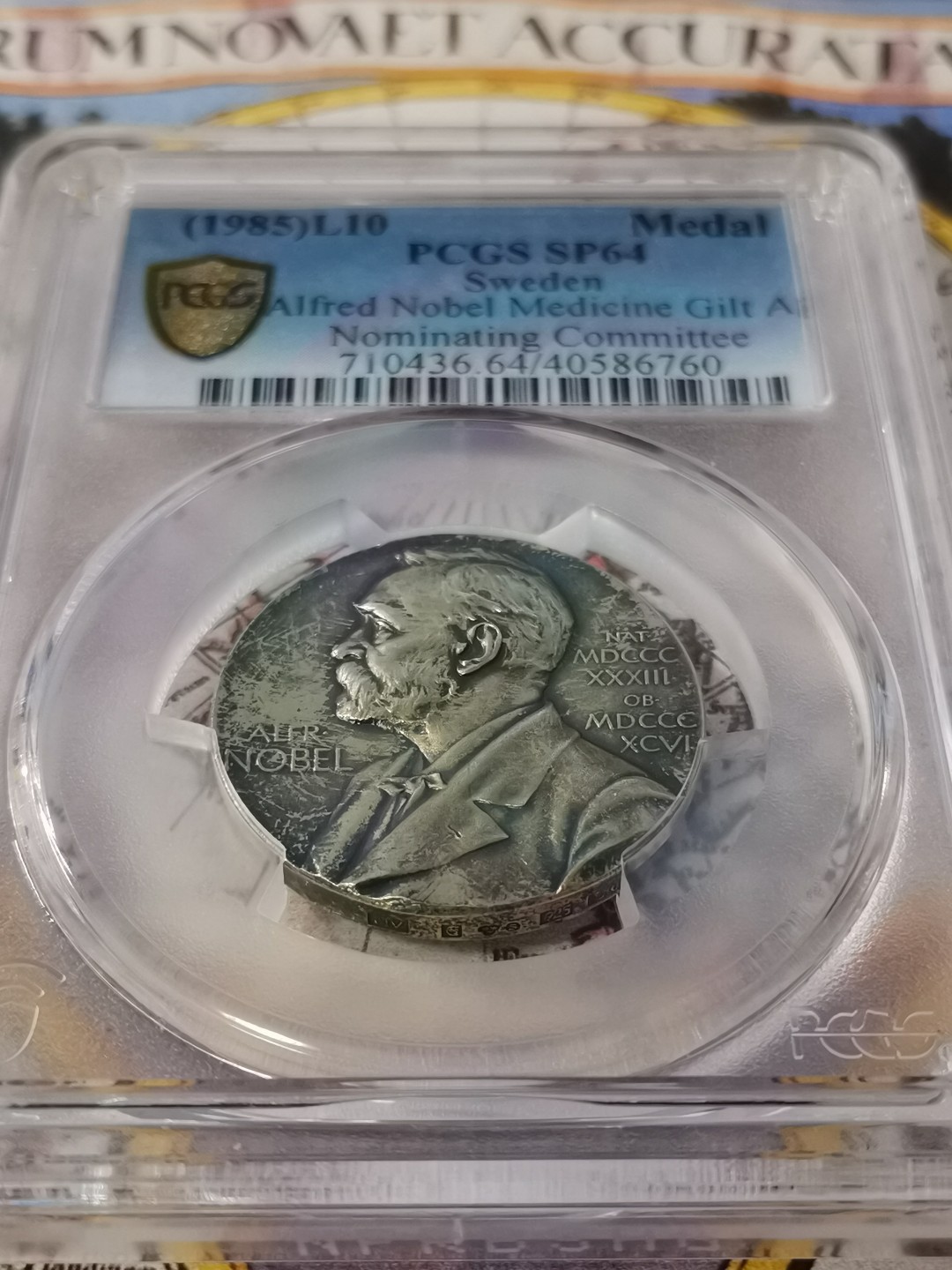 橡树集藏-006场 海纳百川 PCGS-SP64 1985年诺贝尔医学奖镀金银样章，瑞典皇家造币厂铸造，诺贝尔提名委员会颁发，真正的历史荣誉品，错过后悔。独一无二的包浆，实物状态极美。亚军分。正面：諾貝爾半身像朝左；反面：INVENTAS VITAM IUVAT EXCOLUISSE PER ARTES （意：獻給推動人類生活進步的偉大發明家）器皿及埃庫拉皮烏斯的蛇形纏繞權杖；花圈於背。深打，有光帶淺金色調包漿。