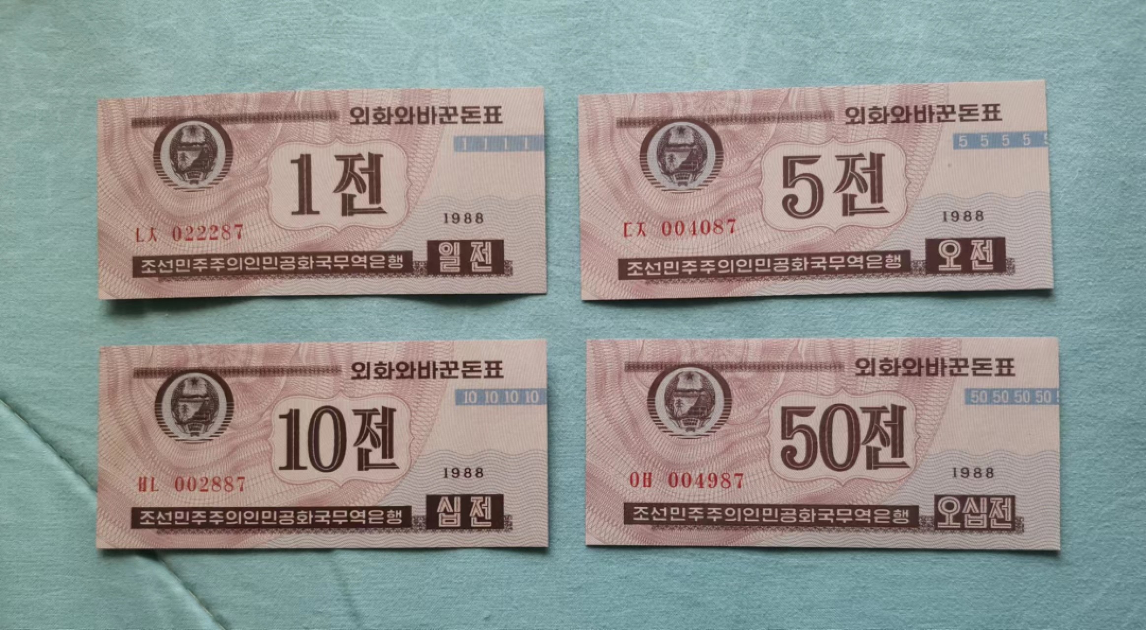世家收藏第十八期“世界杯”号邮票钱币专场（自动截拍） 朝鲜1988年版外汇券（红币）1、5、10、50钱纸钞各一张（其中的三枚流水号码均为四位数字小号）UNC全新