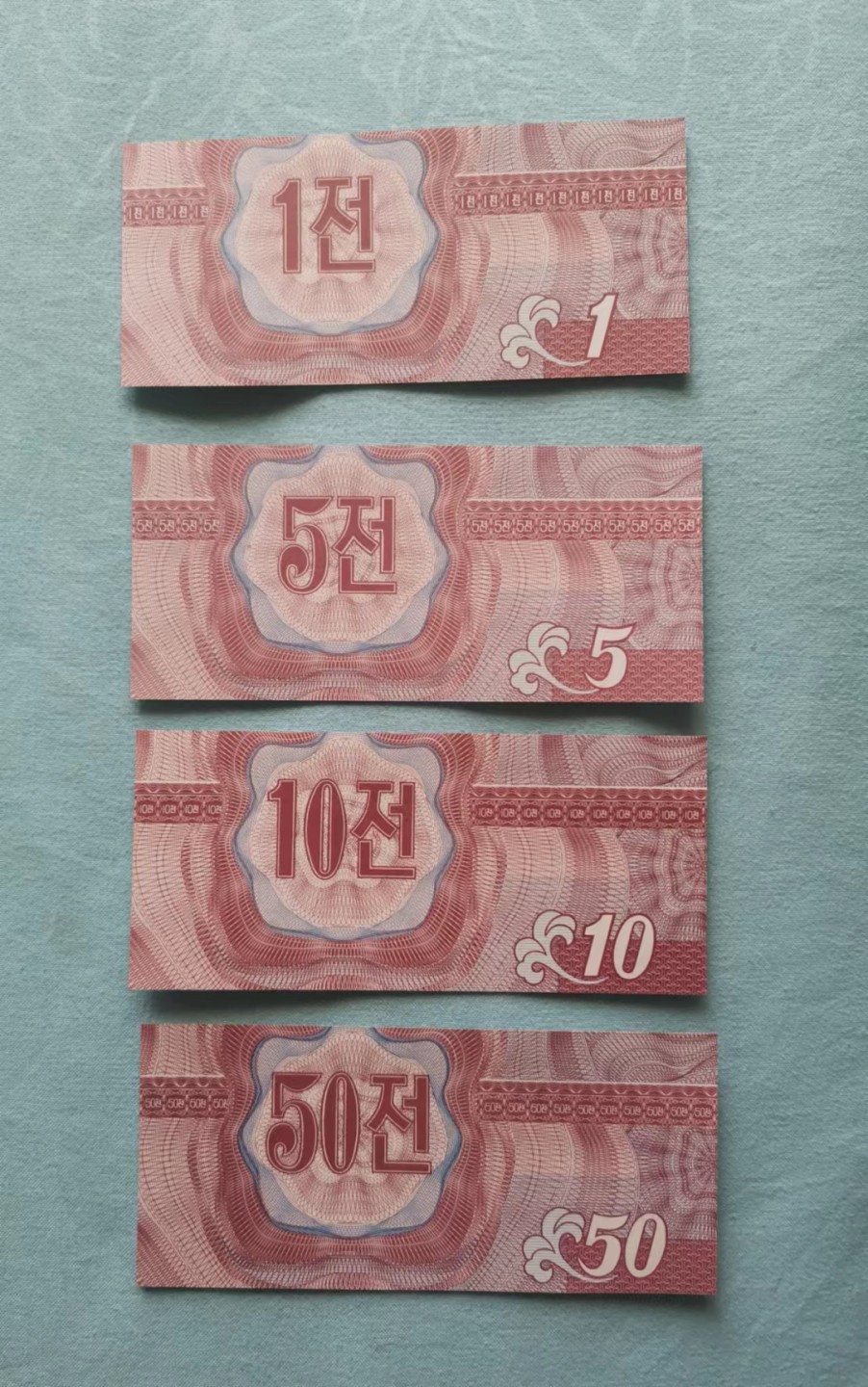 世家收藏第十八期“世界杯”号邮票钱币专场（自动截拍） 朝鲜1988年版外汇券（红币）1、5、10、50钱纸钞各一张（其中的三枚流水号码均为四位数字小号）UNC全新