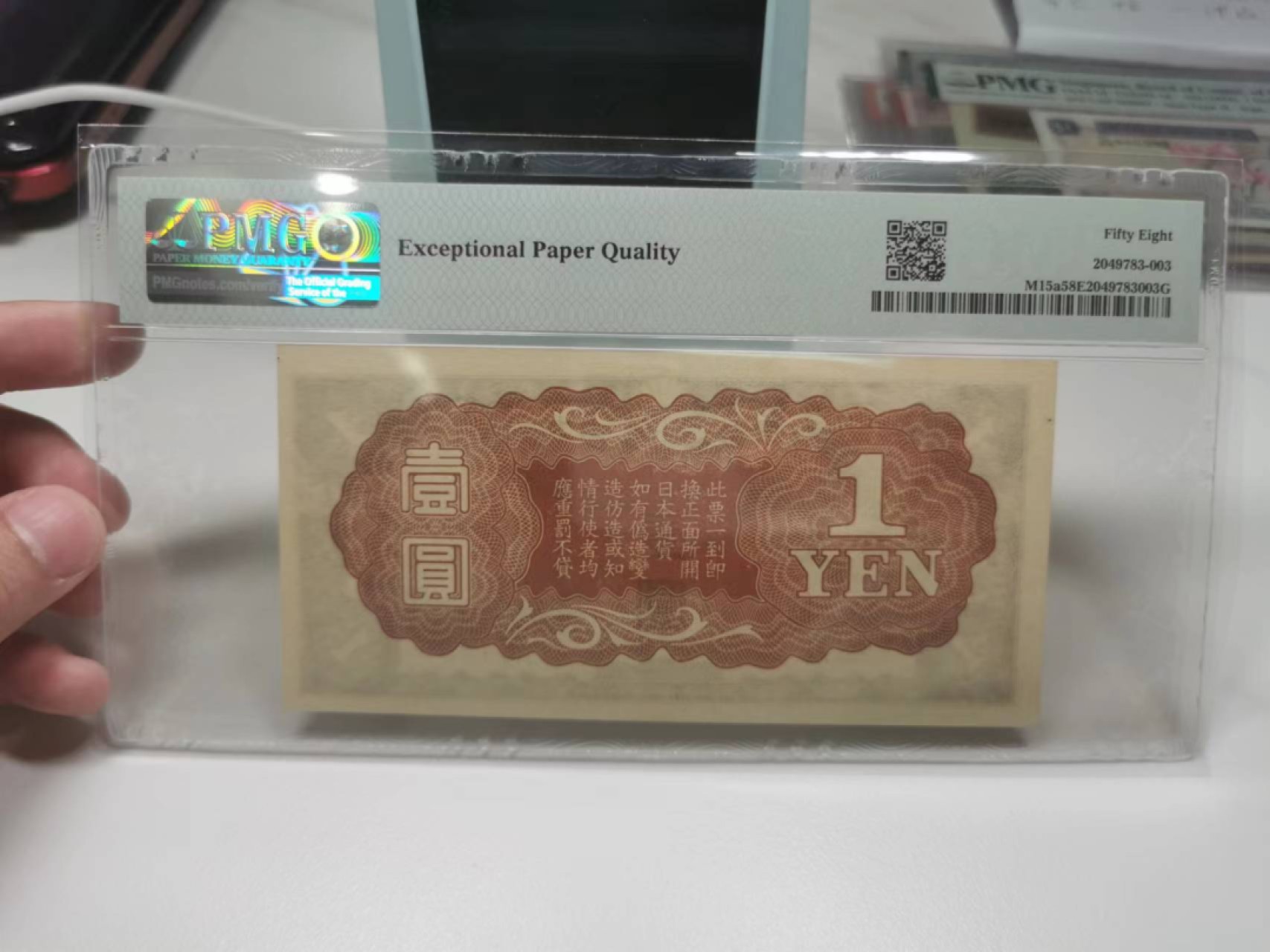 35.【鲸贝乐淘★两拍包邮】道德经·第“是以圣人后其身而身先，外其身而身存”号拍卖 【日本侵华军票】1940年1元，凤凰，PMG58E，底边裁切不齐整