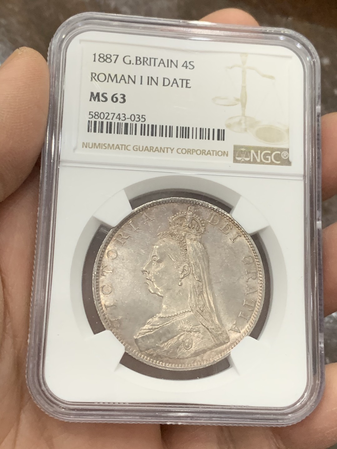 《竞宝斋》第128场-周日，周一 ，2场连拍（全场包邮） NGC-MS63 英国1887年高冠双佛洛林银币，比较少的罗马数字版本，双面呈镜面效果，包浆颜色也是很好看的淡粉彩，上手非常的好看，值得收藏