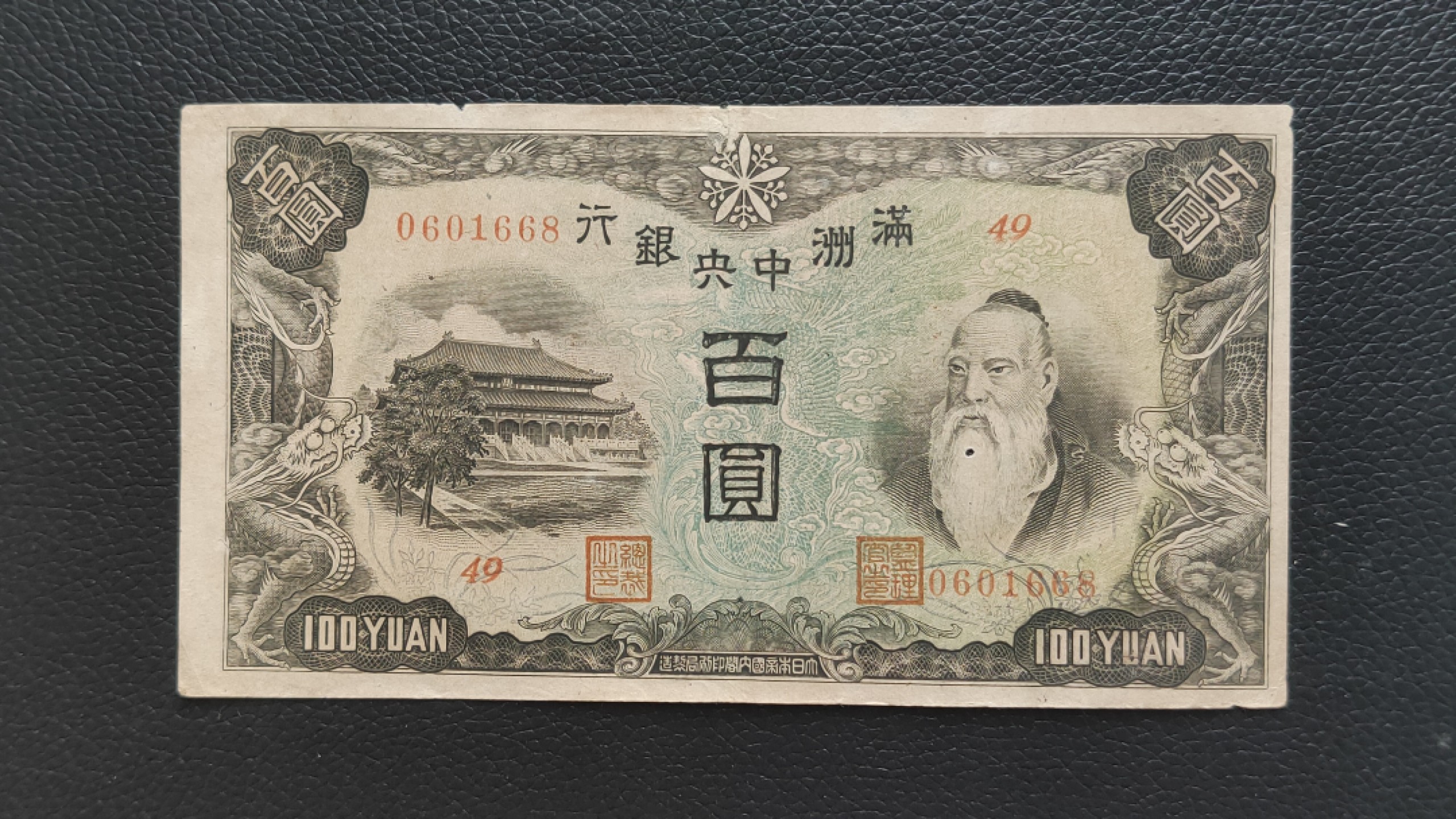 民国裸币专拍 满州中央银行百元  49-0601668 ,尾668，倒置号，胡须处有个小圆洞