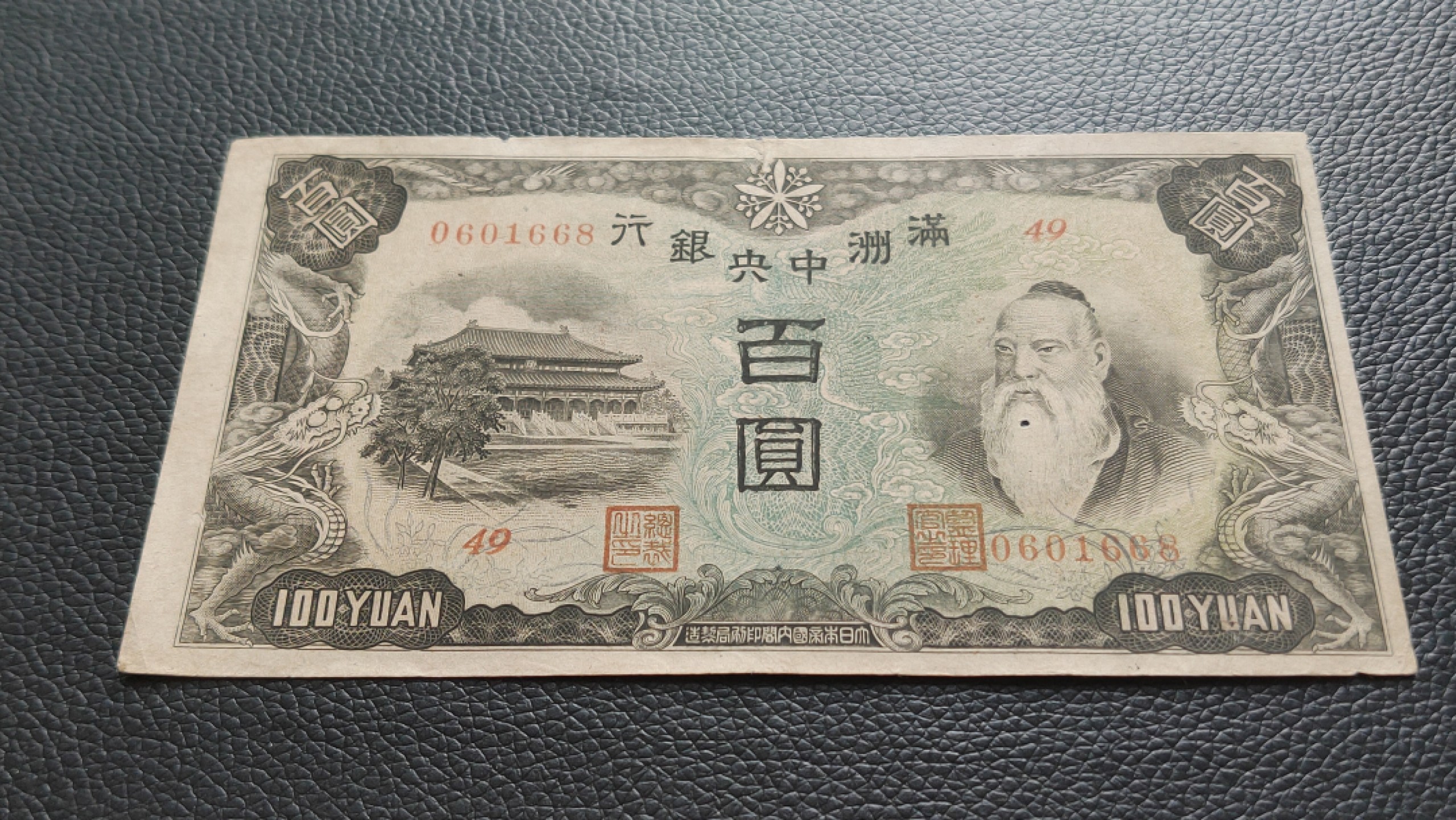 民国裸币专拍 满州中央银行百元  49-0601668 ,尾668，倒置号，胡须处有个小圆洞