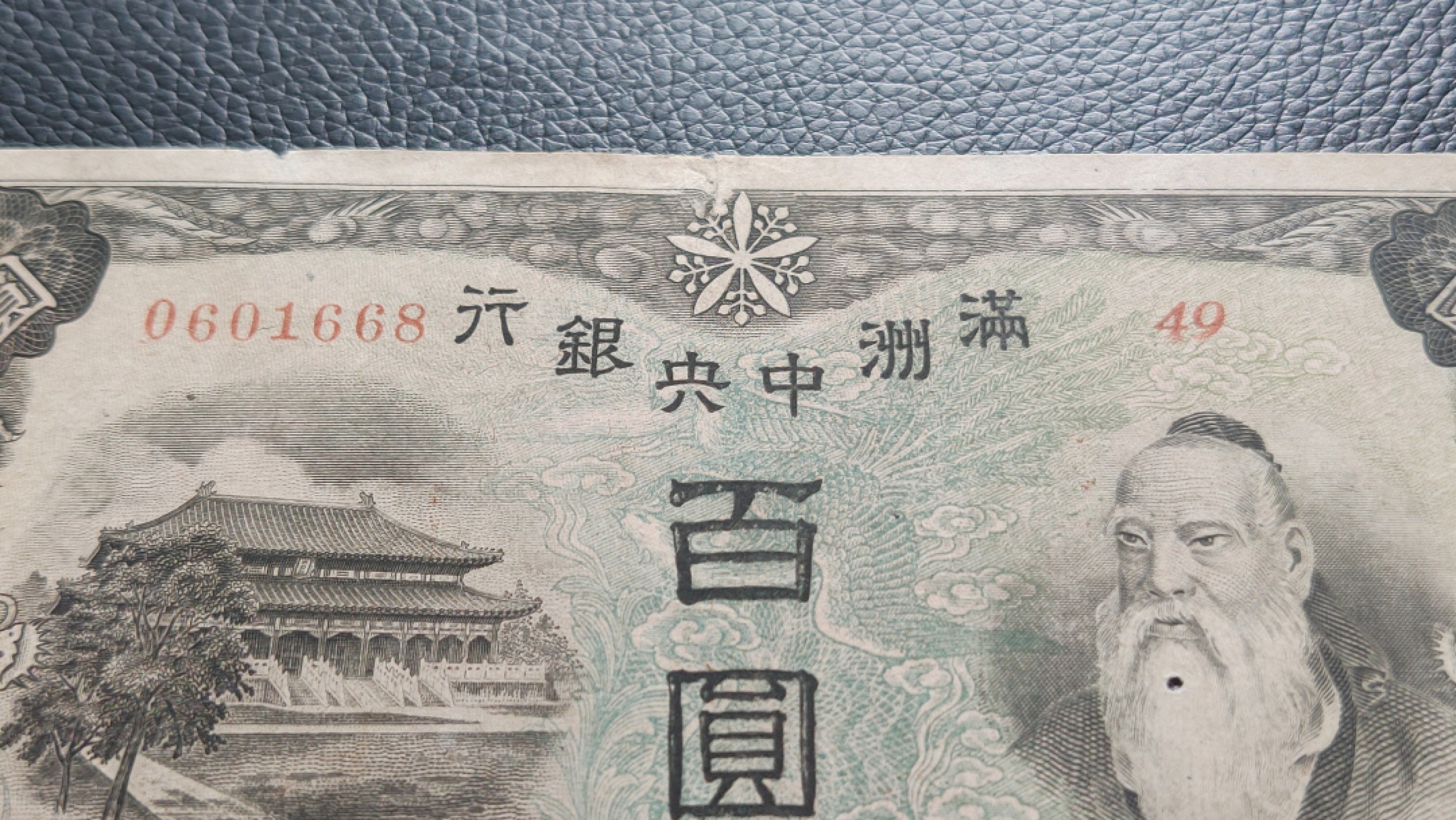 民国裸币专拍 满州中央银行百元  49-0601668 ,尾668，倒置号，胡须处有个小圆洞