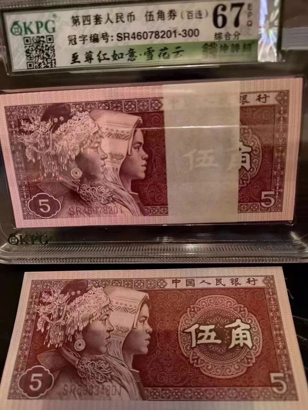 一线荧光币第46期拍场 8005SR至尊如意红，SR04670971_80，裸币标十。至尊红如意的主体颜色呈深枣红色，原本白色的如意纹饰被红色油墨浸染覆盖变成了红色。整个票面油墨厚重油润，凹凸感明显，层次丰富，就像一件浮雕艺术品，显得尊贵典雅，故命名至尊红如意潜力股色差币，一眼清品种