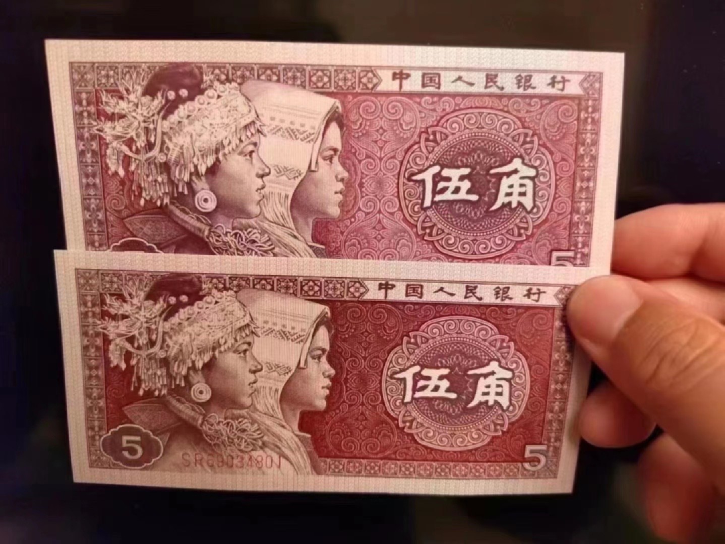 一线荧光币第46期拍场 8005SR至尊如意红，SR04670971_80，裸币标十。至尊红如意的主体颜色呈深枣红色，原本白色的如意纹饰被红色油墨浸染覆盖变成了红色。整个票面油墨厚重油润，凹凸感明显，层次丰富，就像一件浮雕艺术品，显得尊贵典雅，故命名至尊红如意潜力股色差币，一眼清品种