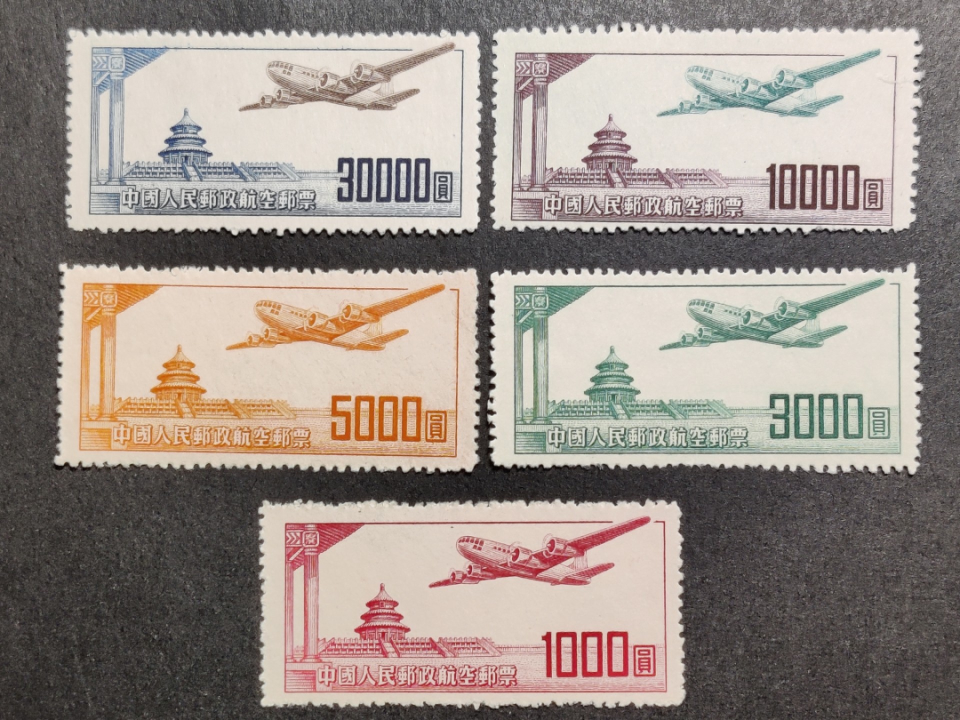 洪涛臻品批发群  精选邮票限时拍卖第一百四十期 航1 航空邮票5全1951年雕刻版  很常见的5000元面值的正面颜色透印到背面,没有出现在这套票,非常难得！完美过灯！ OP全品！