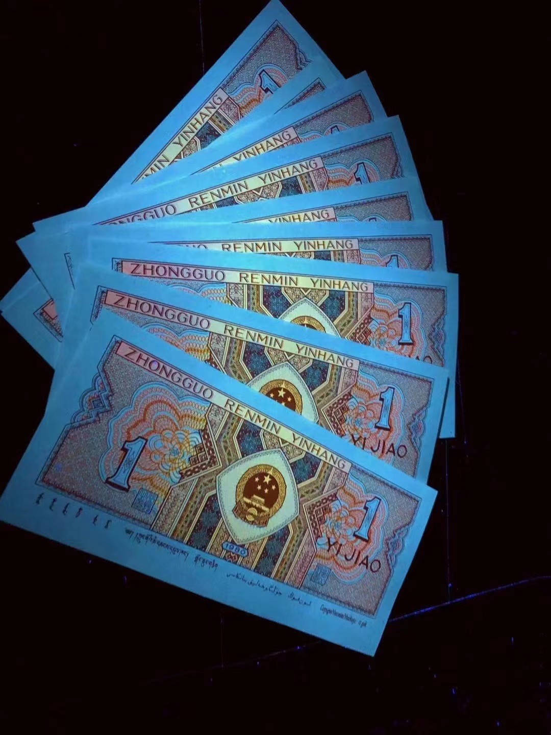 一线荧光币第46期拍场 钱坤评级8001IS强荧光黄金背红，IS99964141，豹子9头，评级币单张。黄金背红的荧光形态在纸币背面属于背红版别里面一个稀少的特殊版别，它结合了黄金甲和背红两个荧光版本的特征，两侧花团是背红，中间的国徽是黄金甲，这个及特殊的状态就形成了一个特殊的版别“黄金背红”。