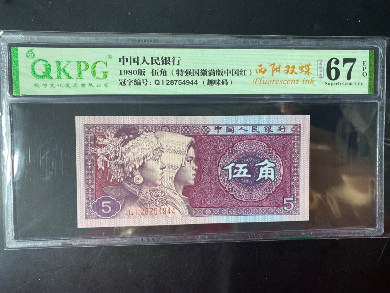 一线荧光币第46期拍场 钱坤评级8005QI西阳双碟，QI28754944，评级币单张，西阳双蝶的荧光形态在背面，是8005满版荧光里左边荧光强于右边荧光的一个新发现，与阴阳双蝶特征恰好相反，中间国徽区域同样呈现金色荧光反应。西阳双蝶的发现呈现出很大的意外性，打破了通过冠号流水推算荧光特征的规律