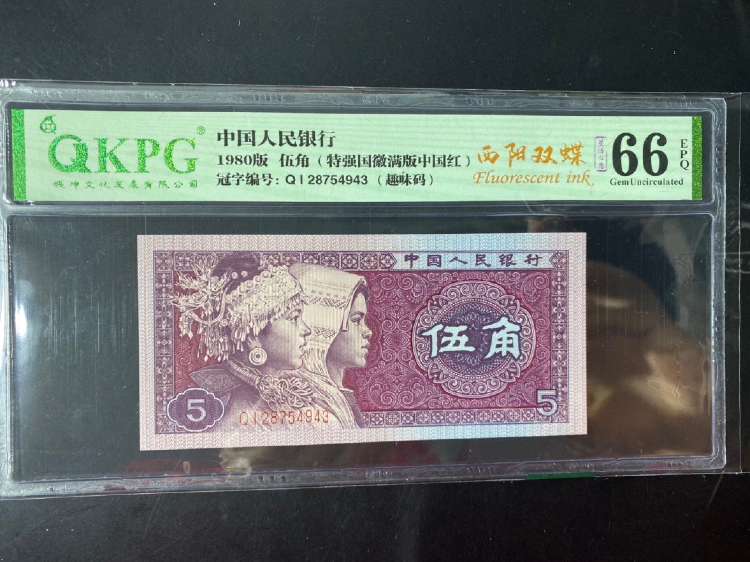 一线荧光币第46期拍场 钱坤评级8005QI西阳双碟，QI28754943，评级币单张，西阳双蝶的荧光形态在背面，是8005满版荧光里左边荧光强于右边荧光的一个新发现，与阴阳双蝶特征恰好相反，中间国徽区域同样呈现金色荧光反应。西阳双蝶的发现呈现出很大的意外性，打破了通过冠号流水推算荧光特征的规律