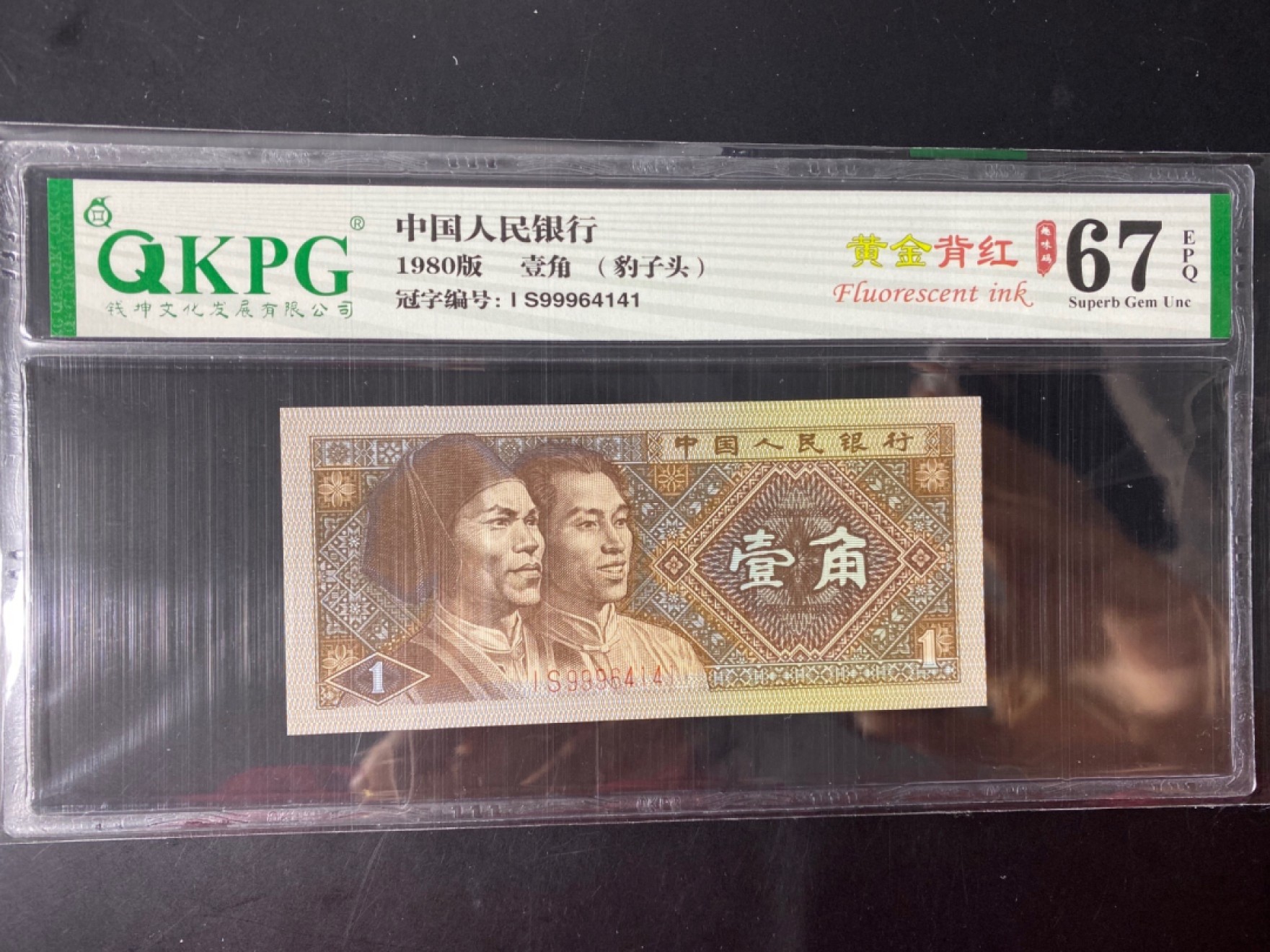 一线荧光币第46期拍场 钱坤评级8001IS强荧光黄金背红，IS99964141，豹子9头，评级币单张。黄金背红的荧光形态在纸币背面属于背红版别里面一个稀少的特殊版别，它结合了黄金甲和背红两个荧光版本的特征，两侧花团是背红，中间的国徽是黄金甲，这个及特殊的状态就形成了一个特殊的版别“黄金背红”。