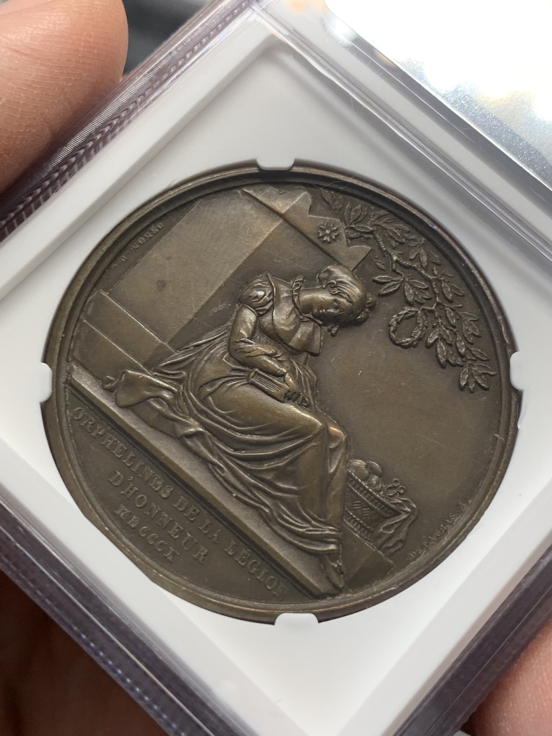 《竞宝斋》第141场-周日，周一 2场 (全场包邮) NGC-MS63BN 唯一亚军分 1810 法国拿破仑一世原铸铜章，设立荣誉军团孤儿教育之家。席地而坐的少女手捧书本，刻画细腻。加厚盒，巧克力包浆