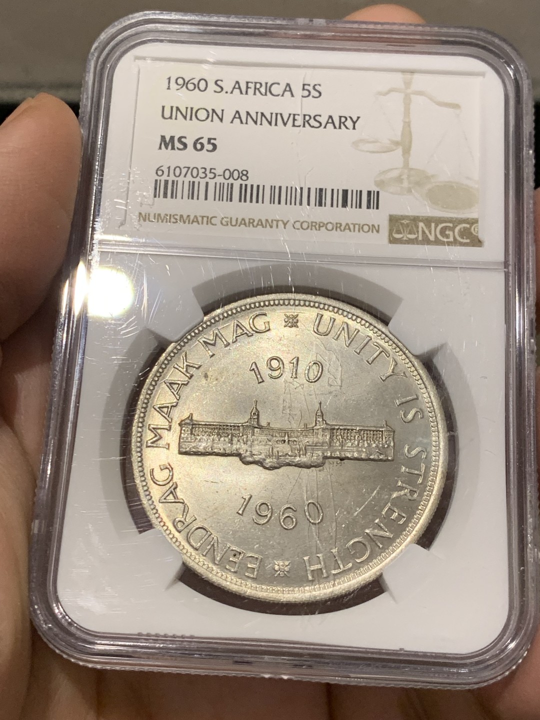 《竞宝斋》第141场-周日，周一 2场 (全场包邮) NGC-MS65 英属南非 1960 南非联盟成立50周年纪念5先令大银币，车轮转光，65难得高分。盒子上有小划，保存无碍