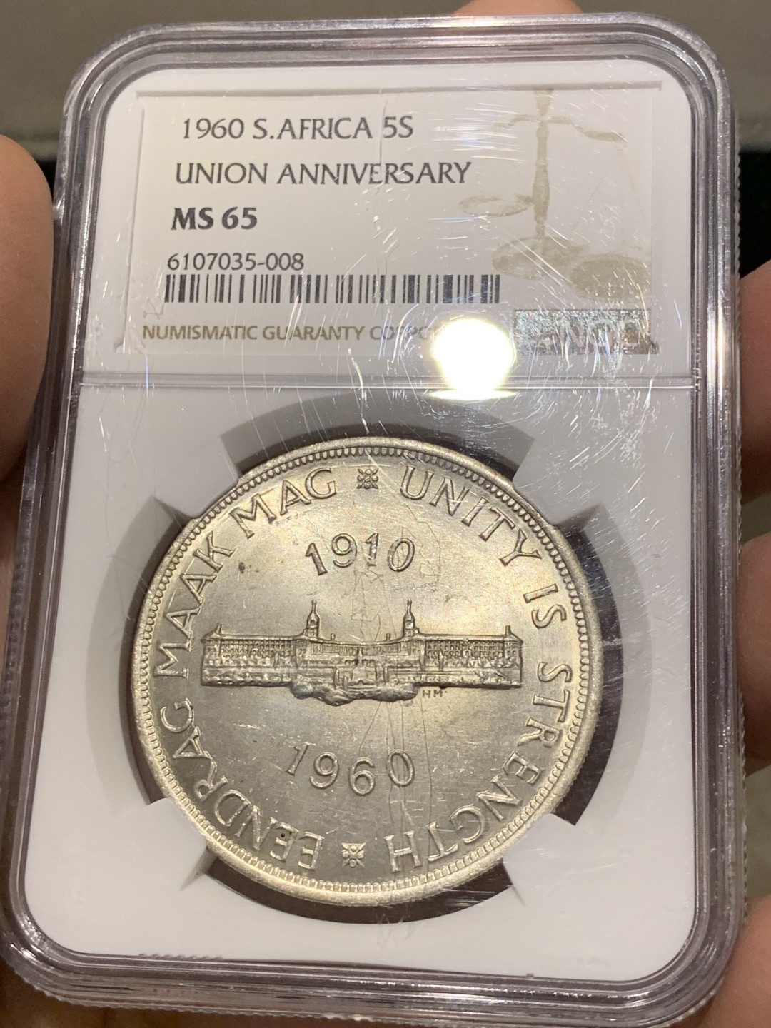 《竞宝斋》第141场-周日，周一 2场 (全场包邮) NGC-MS65 英属南非 1960 南非联盟成立50周年纪念5先令大银币，车轮转光，65难得高分。盒子上有小划，保存无碍