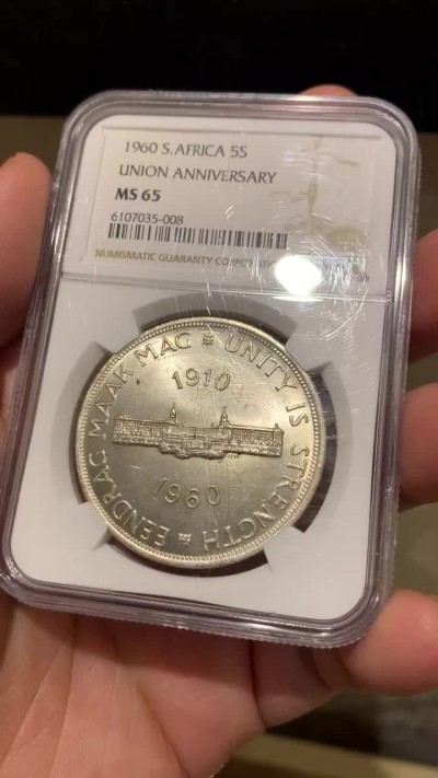 《竞宝斋》第141场-周日，周一 2场 (全场包邮) NGC-MS65 英属南非 1960 南非联盟成立50周年纪念5先令大银币，车轮转光，65难得高分。盒子上有小划，保存无碍