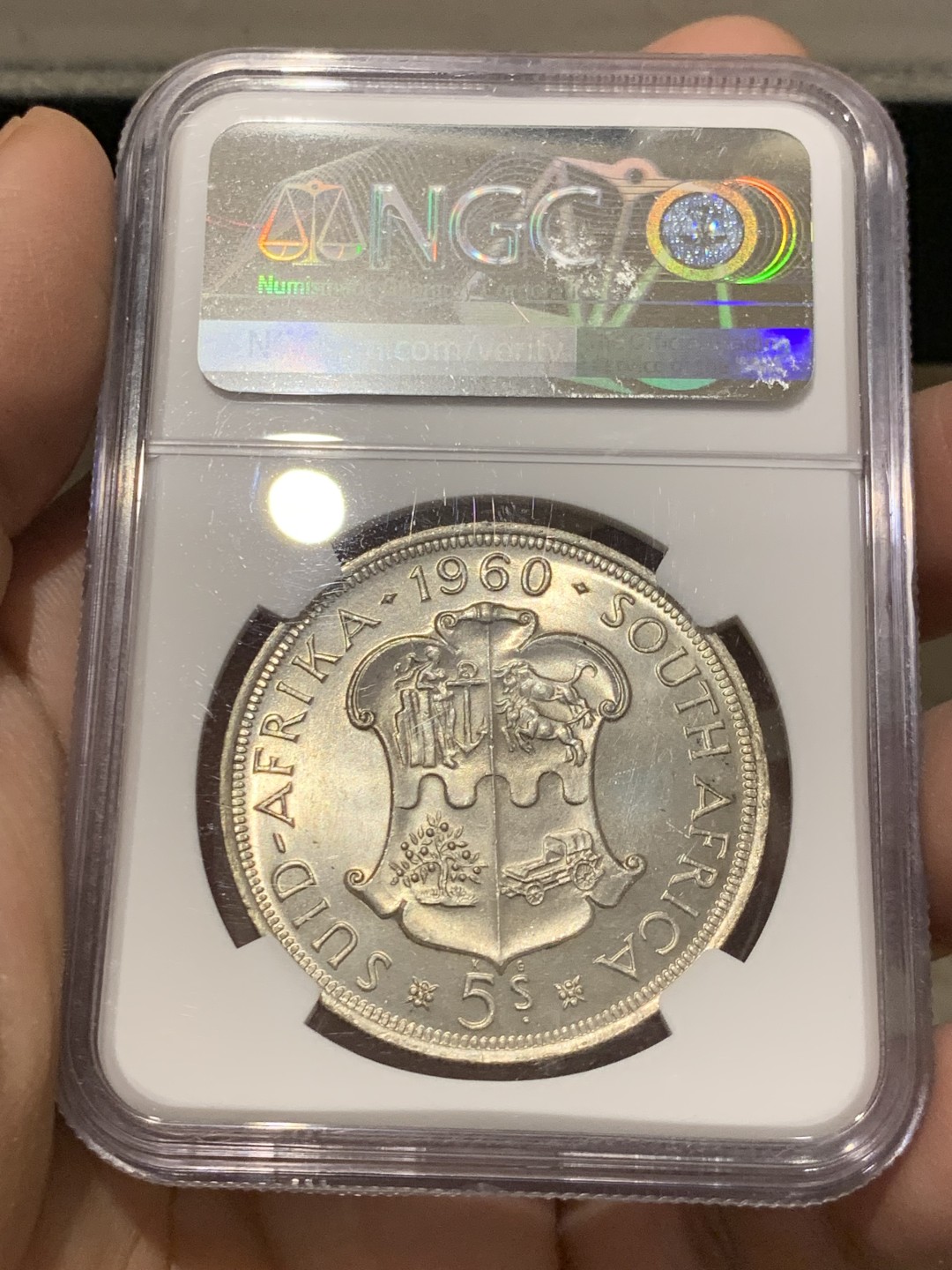 《竞宝斋》第141场-周日，周一 2场 (全场包邮) NGC-MS65 英属南非 1960 南非联盟成立50周年纪念5先令大银币，车轮转光，65难得高分。盒子上有小划，保存无碍