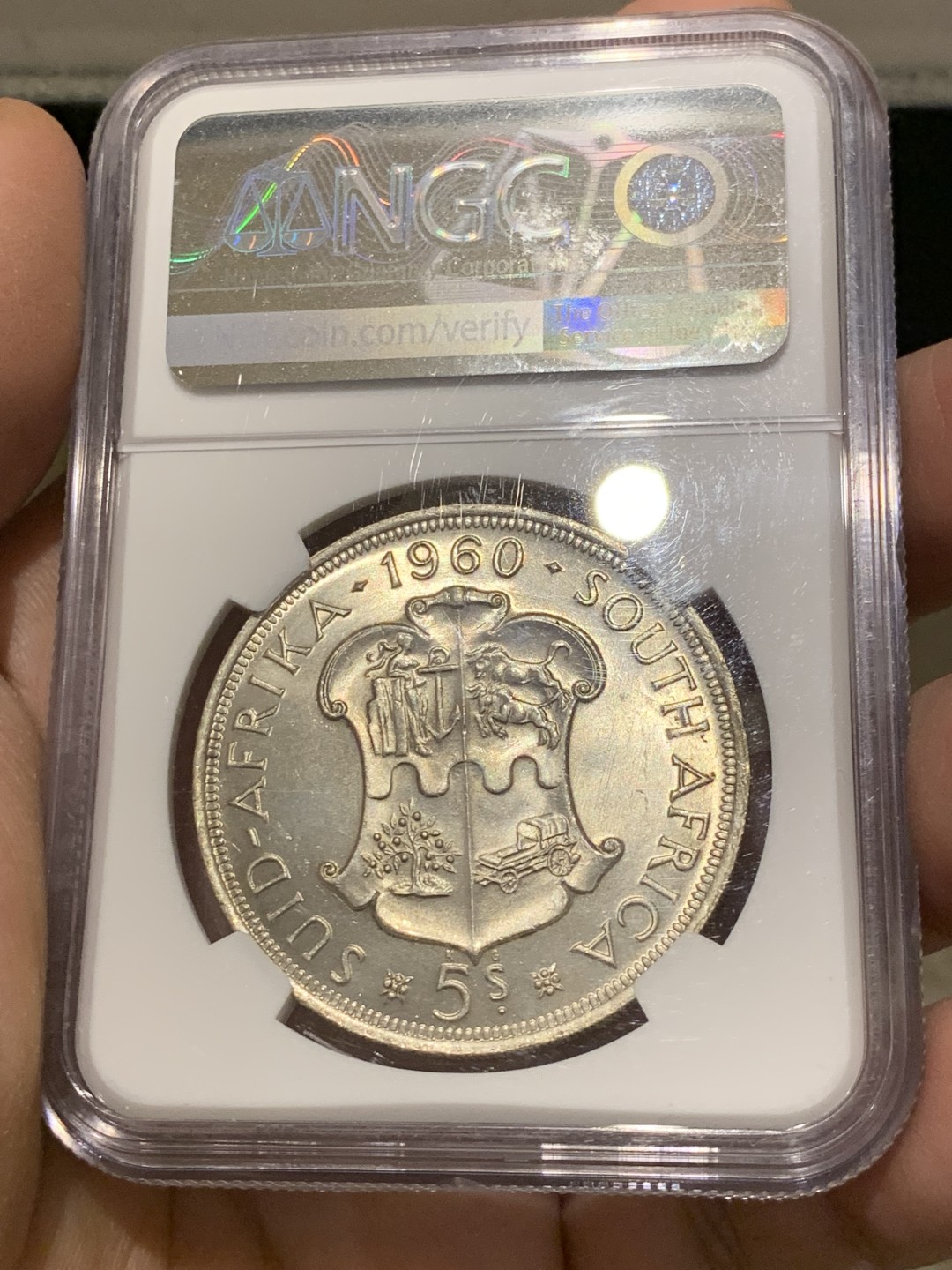 《竞宝斋》第141场-周日，周一 2场 (全场包邮) NGC-MS65 英属南非 1960 南非联盟成立50周年纪念5先令大银币，车轮转光，65难得高分。盒子上有小划，保存无碍