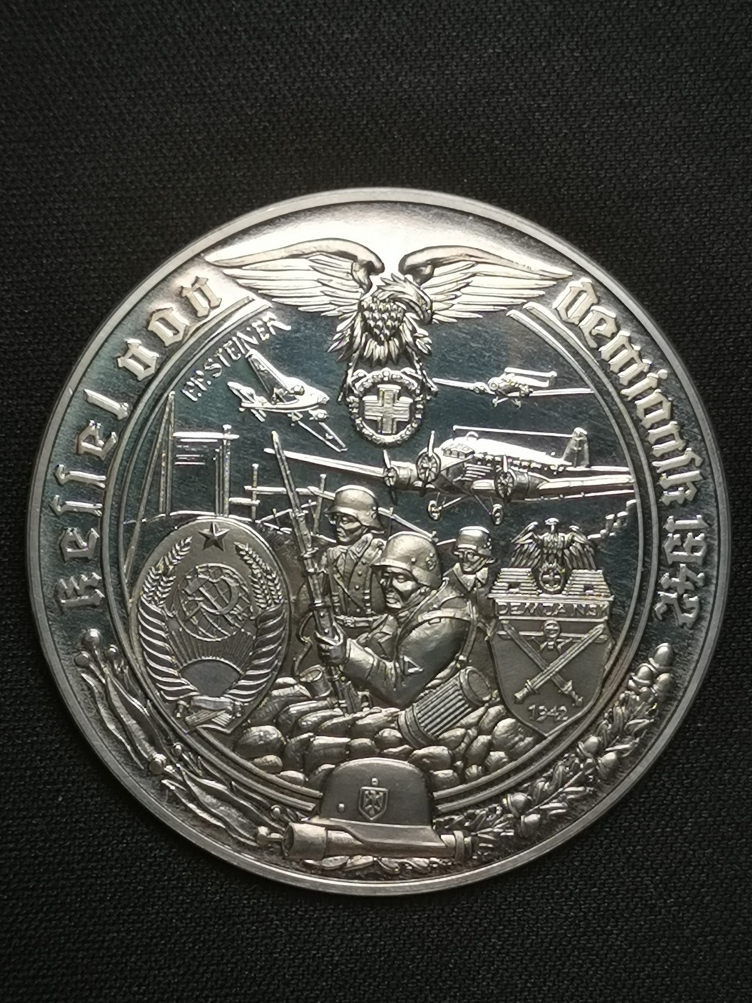 万国钱币拍卖第005期 第二次世界大战纪念章，1977年德国出品，一套共50枚，999高银，在主要战役、高级将领、新式武器等方面介绍了二战期间的战争历程，背面统一设计（见末图），可以视为钱币版的二战纪实录。统一直径50MM，重量35G，精制喷砂光边工艺制作，总重量达到1750KG。