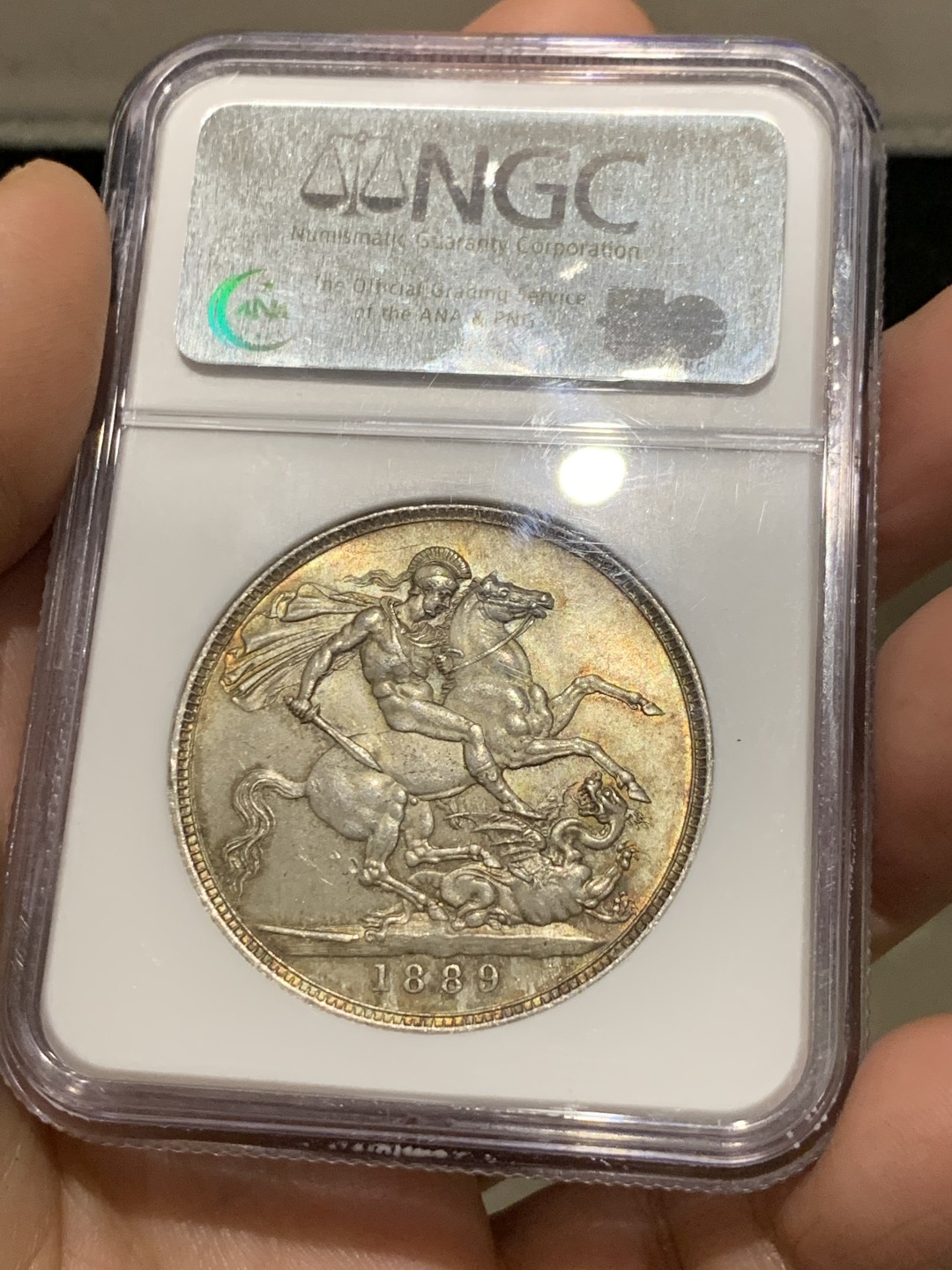 《竞宝斋》第149场-周日，周一，周四 3场 (全场包邮) NGC-MS64 英国1889年维多利亚马剑克朗银币，带些许金黄色包浆，底板车轮光顺滑，该年份亚军分，其上N仅有一枚65，P仅有64+及65各一枚