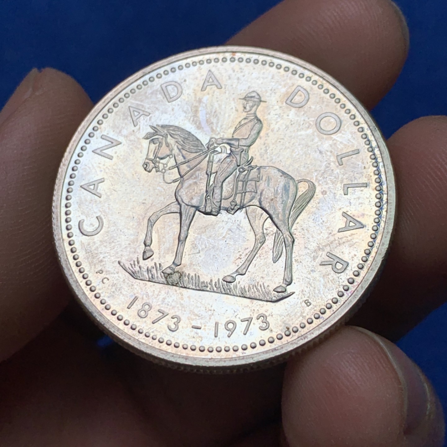 《竞宝斋》三少爷老婆本专场-第156场 (全场包邮) 加拿大1973年皇家骑警成立100周年纪念1元银币，漂亮的彩色包浆