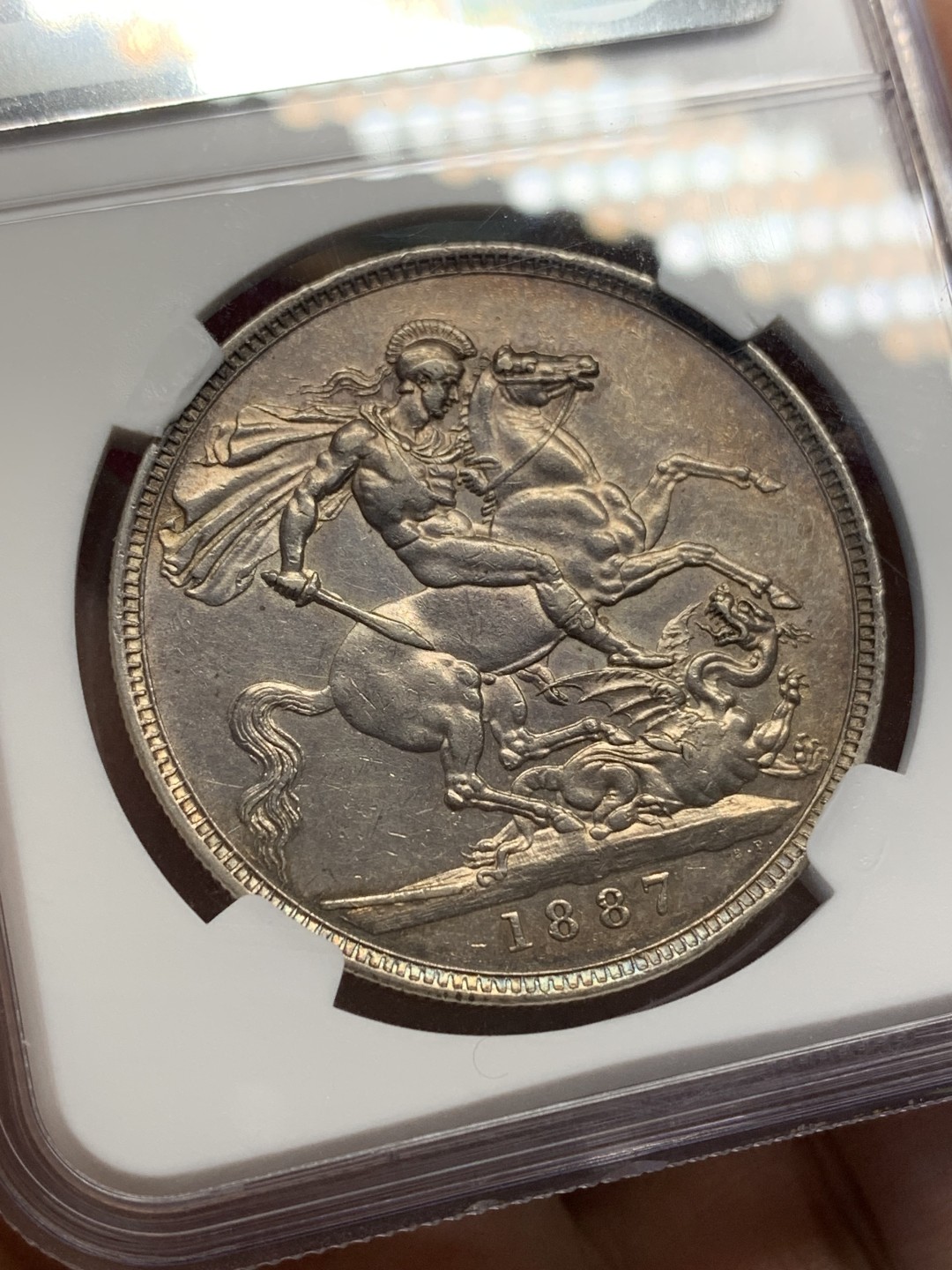 《竞宝斋》第159场-周日，周一 2场 (全场包邮) NGC-AU55 英国 1887年 1克朗 马剑图案经典，包浆带五彩。明显低评