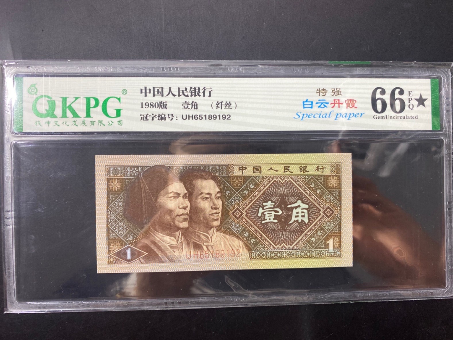 一线荧光币第120期拍场 钱坤评级8001UH特强白云丹霞，UH65189192，评级币单张。特点一：“白云”为纸张白色荧光（偶尔伴有纤丝纤云特点），和普通8001相比区别明显，整刀5种荧光效果中包含普通黄金甲。特点二：“丹霞”为票面正面的红蓝色网格荧光，加上纸张的白色荧光形成了美妙的“白云丹霞”效果。