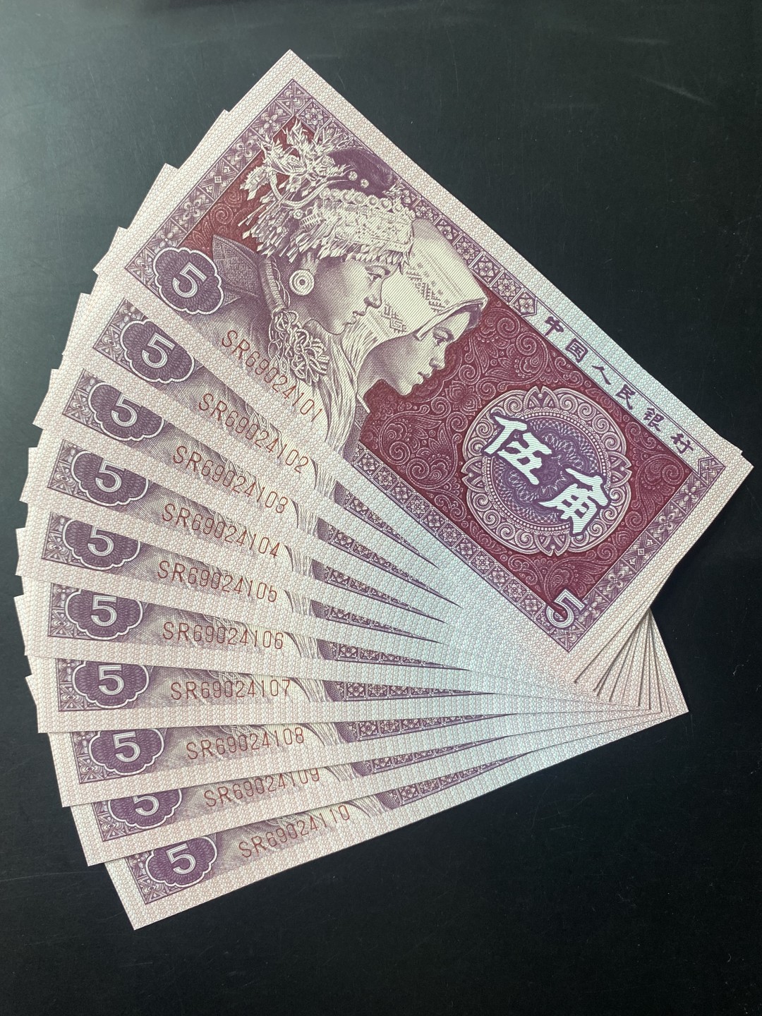 一线荧光币第120期拍场 8005SR至尊如意红，SR69024101_10，裸币标十，至尊红如意的主体颜色呈深枣红色，原本白色的如意纹饰被红色油墨浸染覆盖变成了红色。整个票面油墨厚重油润，凹凸感明显，层次丰富，就像一件浮雕艺术品，显得尊贵典雅，故命名至尊红如意潜力股色差币，一眼清品种