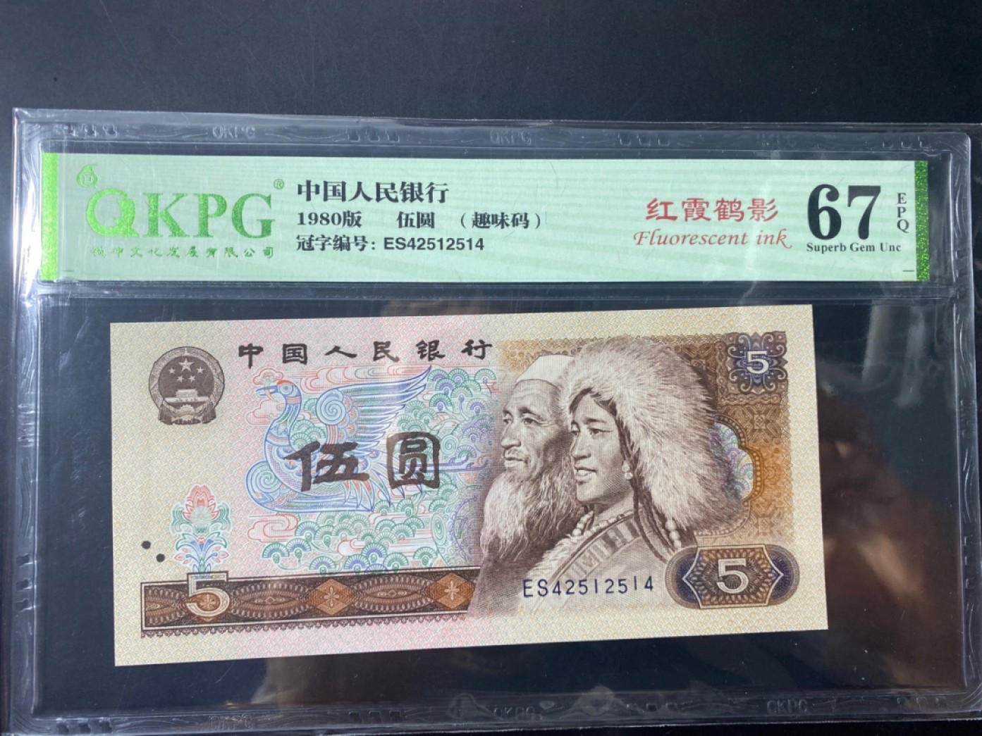 一线荧光币第120期拍场 钱坤评级805ES天王冠红霞鹤影，ES42512514，评级币单张。苍松翠鹤主要荧光特点为票面正面在365荧光灯下整版为淡黄色网格荧光，松鹤有翠绿色，淡粉色荧光。红霞鹤影主要荧光特点为票面正面在365荧光灯下整版为淡黄色网格荧光，松鹤位置的底纹网格为红色