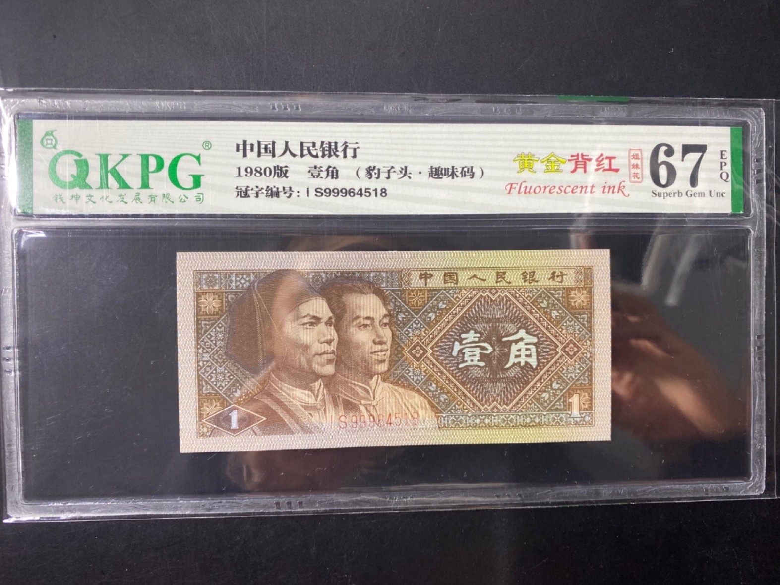 一线荧光币第120期拍场 钱坤评级8001IS强荧光黄金背红，IS99964518，豹子9头，评级币单张。黄金背红的荧光形态在纸币背面属于背红版别里面一个稀少的特殊版别，它结合了黄金甲和背红两个荧光版本的特征，两侧花团是背红，中间的国徽是黄金甲，这个及特殊的状态就形成了一个特殊的版别“黄金背红”。