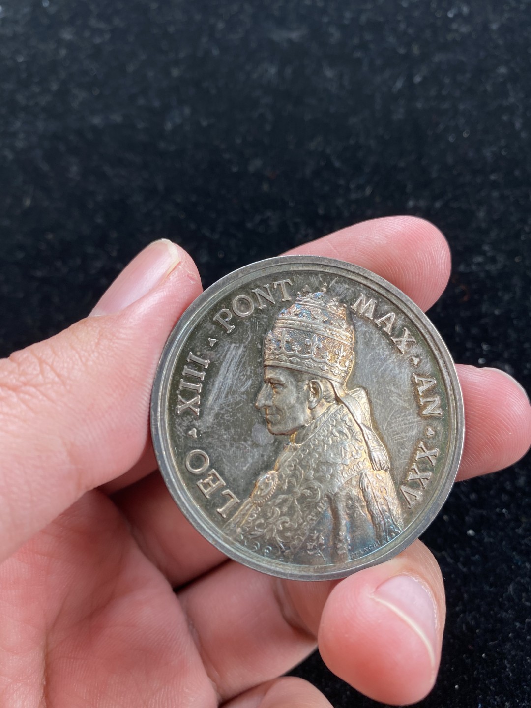 万国钱币拍卖第007期（慕尼黑第二夜） 1902梵蒂冈利奥十三世教皇银章，光边，教皇面金彩，孔雀蓝彩，背面金蓝灰三色环形彩，高浮雕设计，高点俱在，教皇头冠，衣饰细节动人，直径43mm，重35.4g。