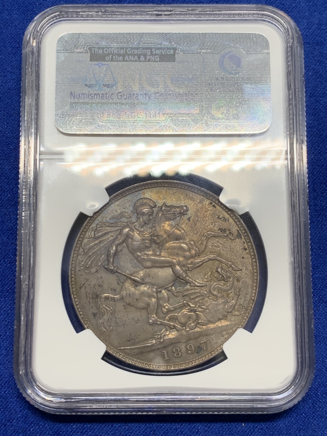 欢迎参加《竞宝斋》五一特拍-第161场-周日，周一 2场 NGC MS62 英国1897年维多利亚披纱马剑1克朗银币，纽曼旧藏重彩包浆
