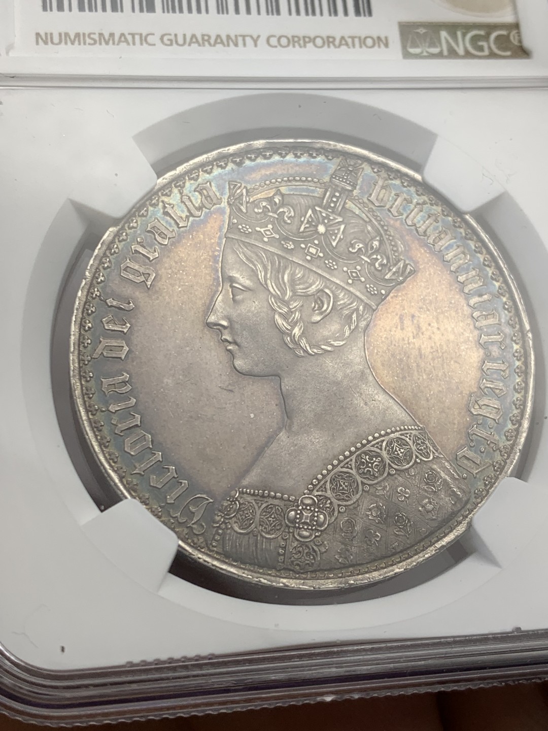 欢迎参加《竞宝斋》五一特拍-第161场-周日，周一 2场 NGC PF62CAMEO 英国 1847年 哥特克朗 大名誉品 带cam的很少 该枚底板镜面效果明显 女王人像中心紫红彩 外围深蓝环彩 背面深蓝环彩 底板干净清爽 无明显拉丝 综合非常棒的一枚哥特克朗