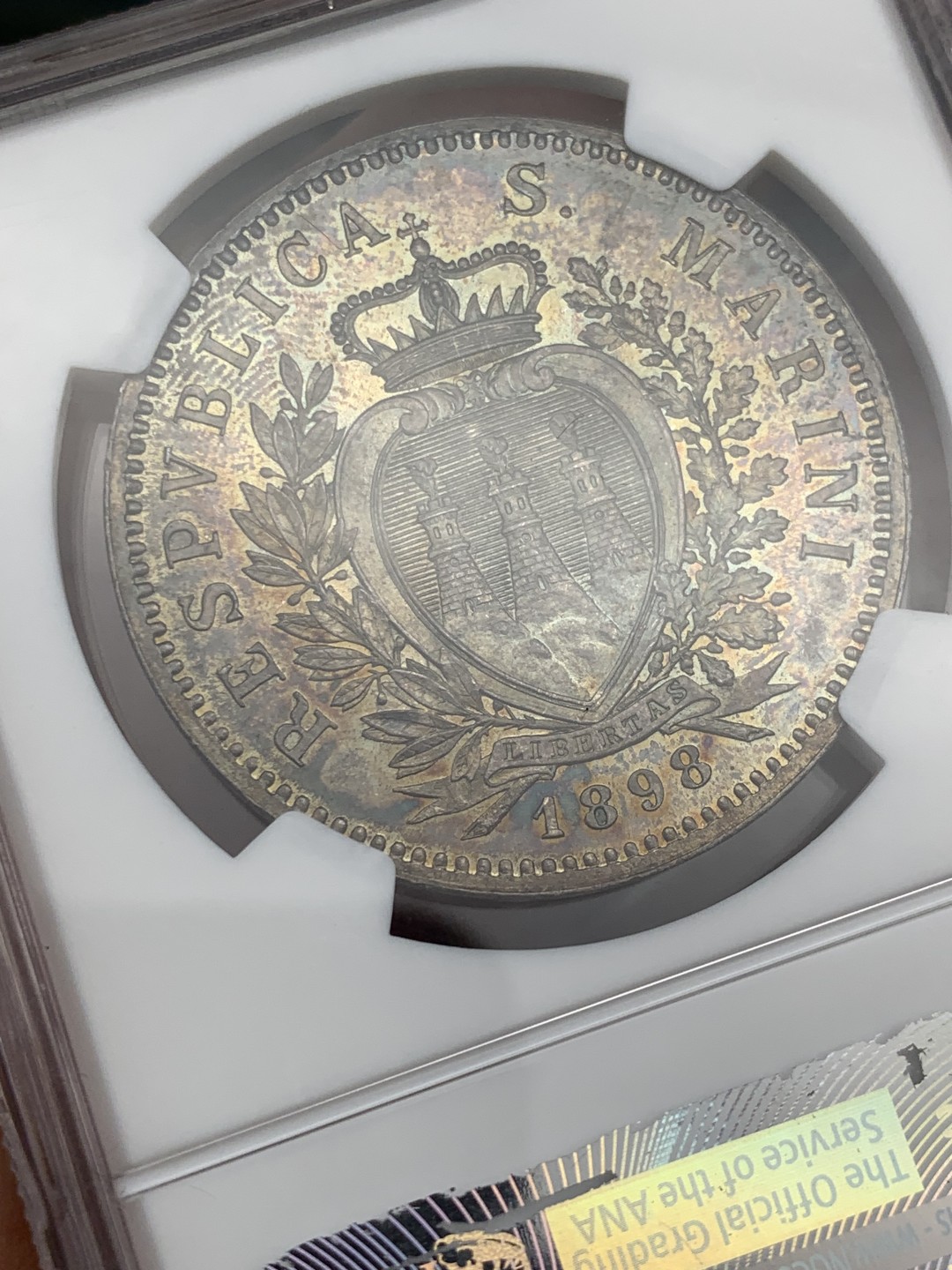 欢迎参加《竞宝斋》五一特拍-第161场-周日，周一 2场 NGC-MS63 圣马力诺 1898年 5里拉 银币 深色五彩 绝美收藏级