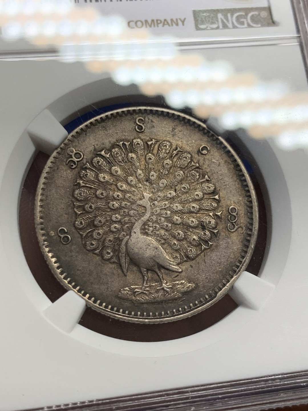 欢迎参加《竞宝斋》五一特拍-第161场-周日，周一 2场 NGC AU58 1852年缅甸孔雀kyat银币 原色黑彩 羽毛清晰完整 大涨品种